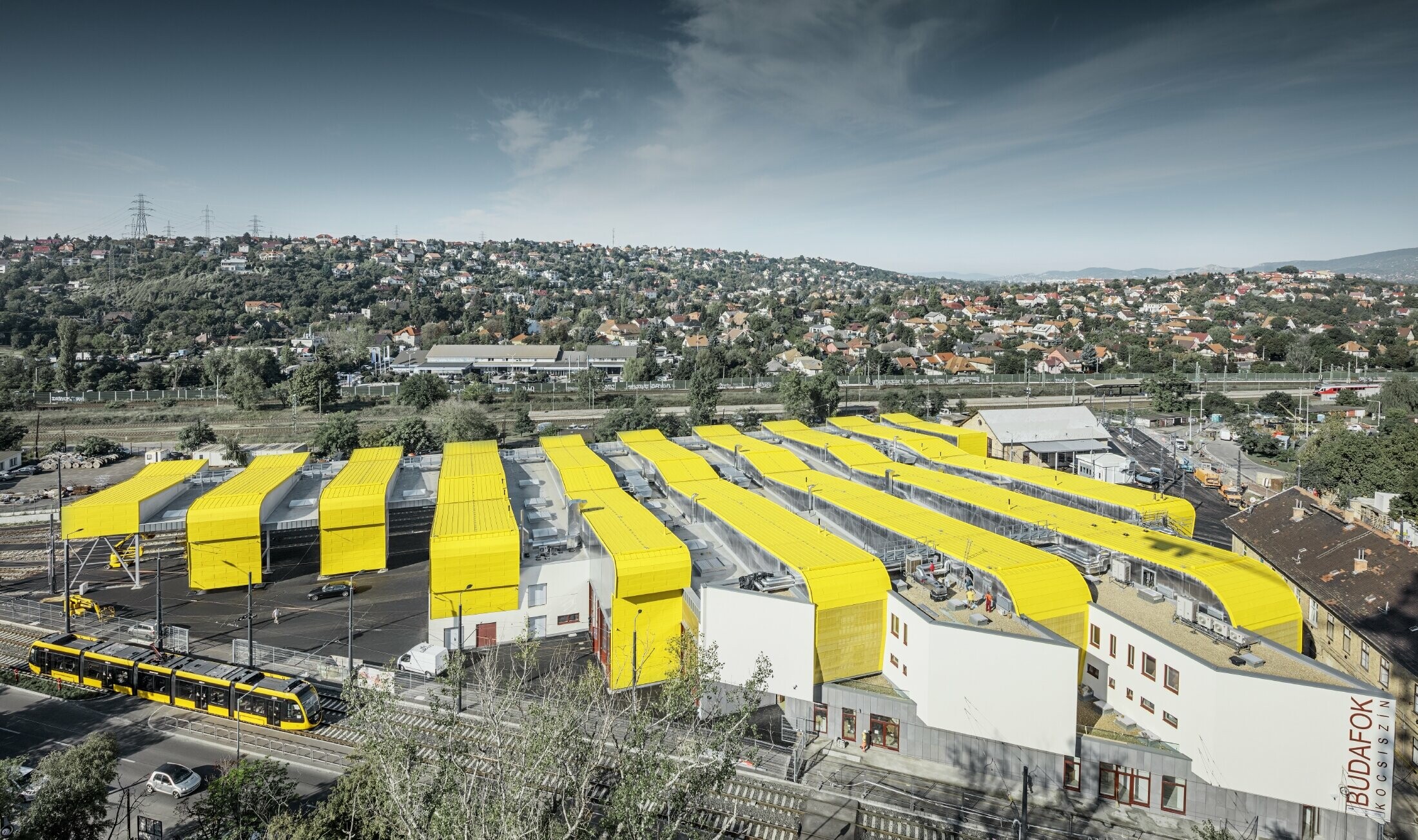Aerial view of the remise in Budapest. The buildings are clad in PREFA Prefalz in the special traffic yellow coating, RAL 1023.