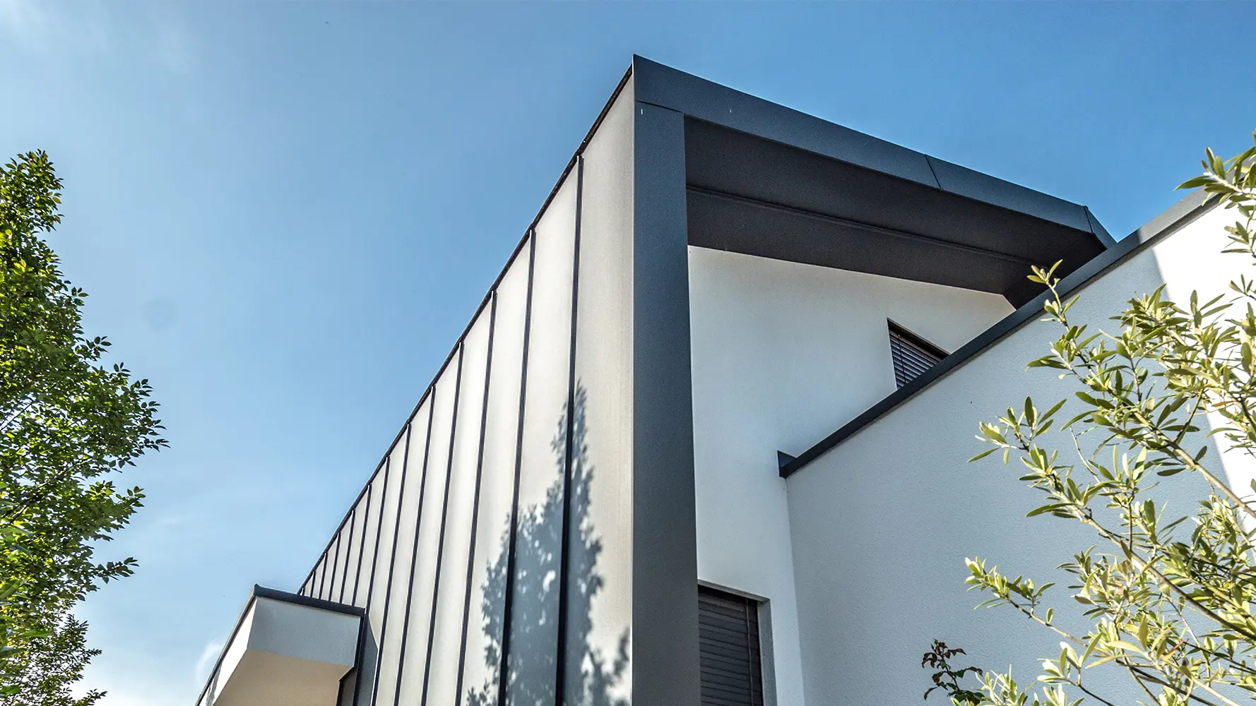 Modern detached house with white plaster façade and standing seam roof and  façade with Prefalz from PREFA in anthracite