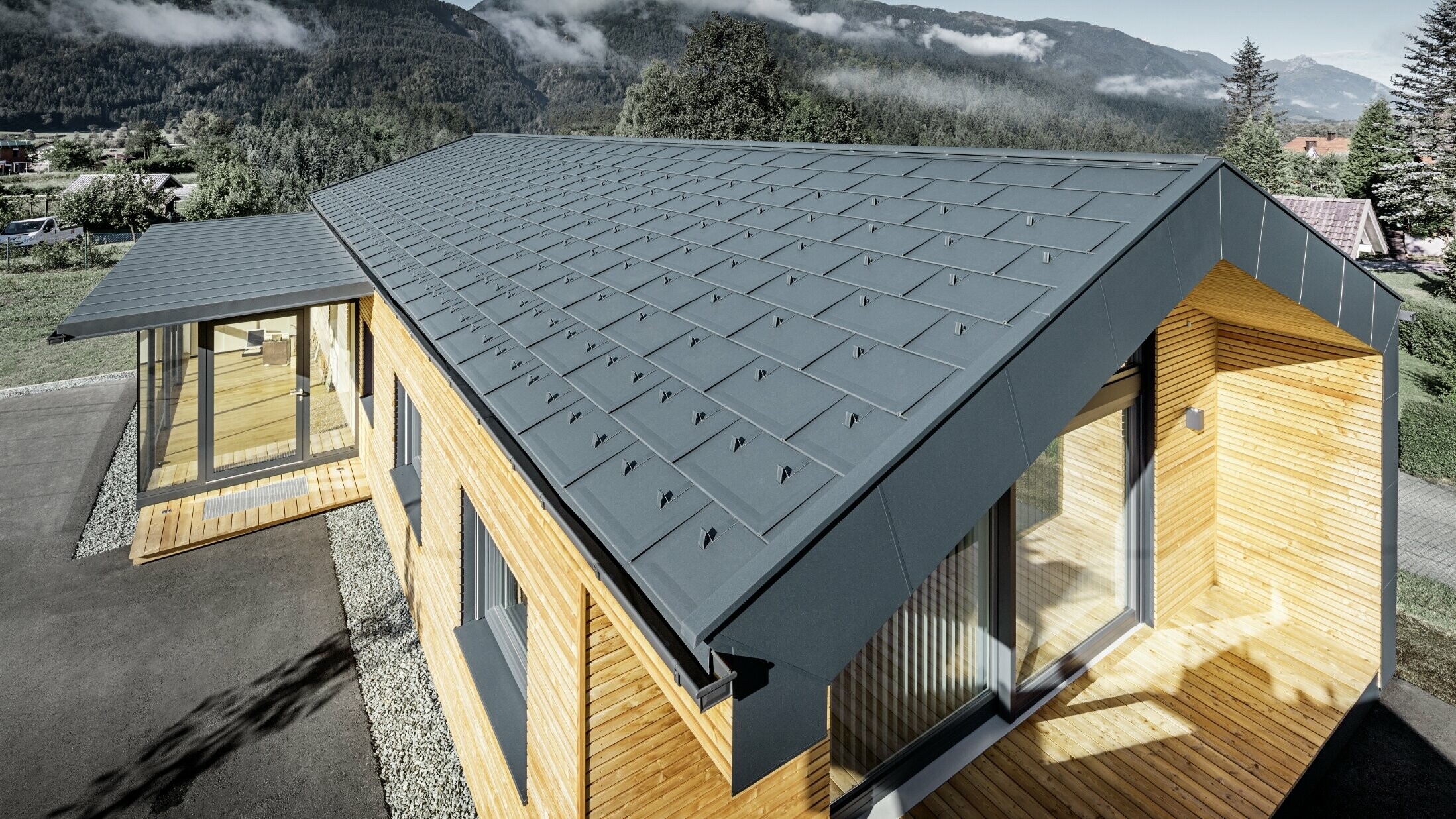 New office building of Holzbau Faltheiner with a larch wood façade, large windows and a PREFA roof in anthracite.