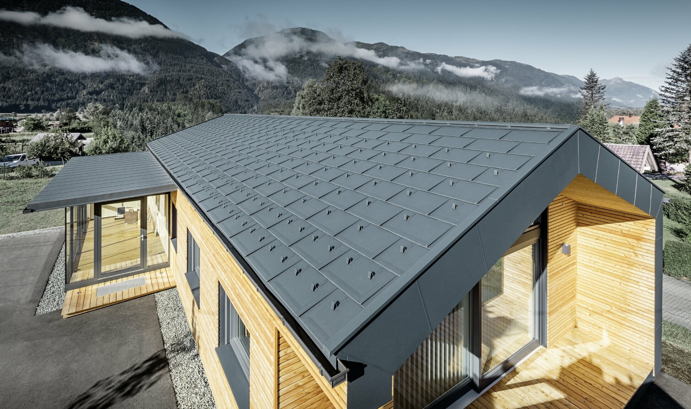 New office building of Holzbau Faltheiner with a larch wood façade, large windows and a PREFA roof in anthracite.