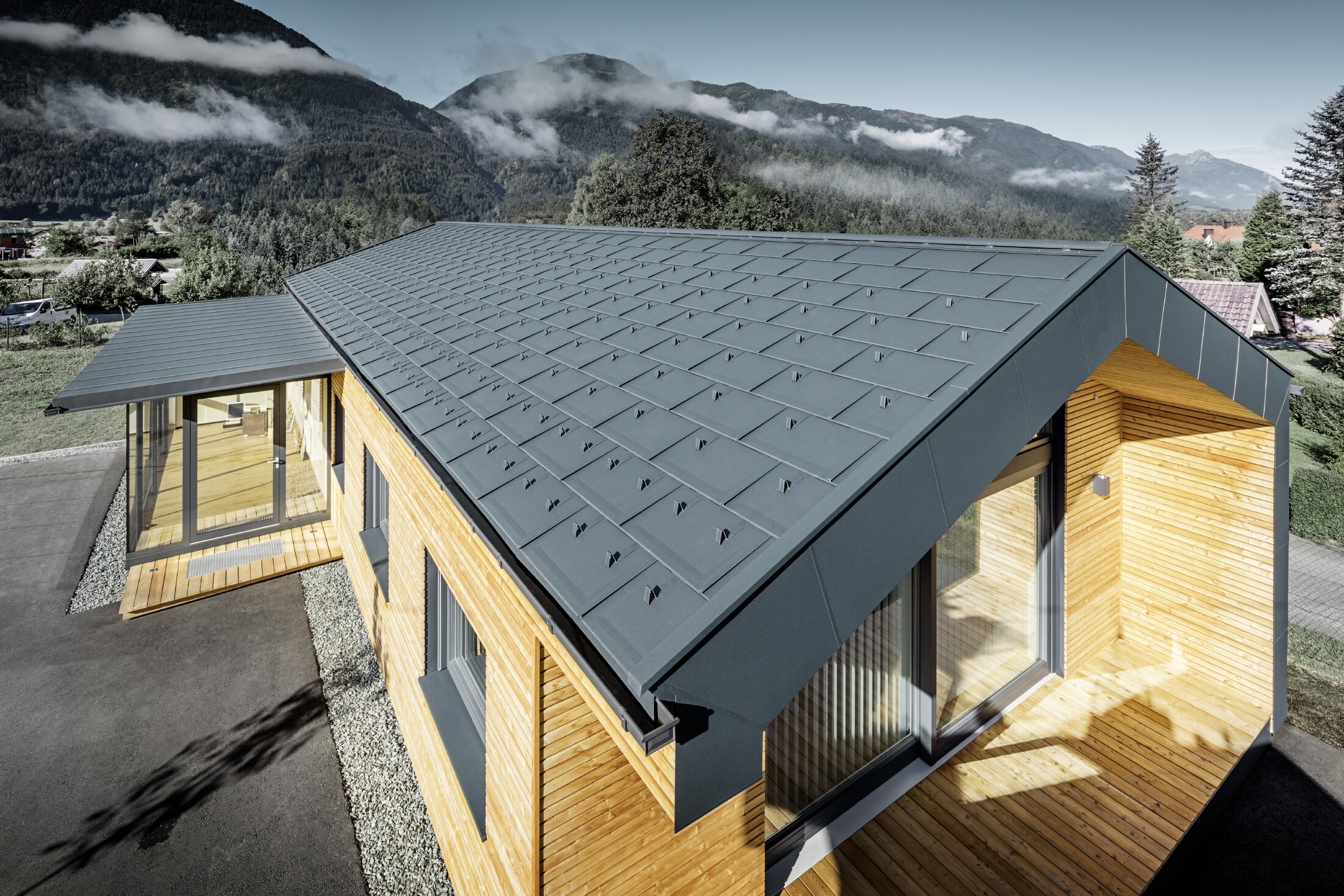 New office building of Holzbau Faltheiner with a larch wood façade, large windows and a PREFA roof in anthracite.