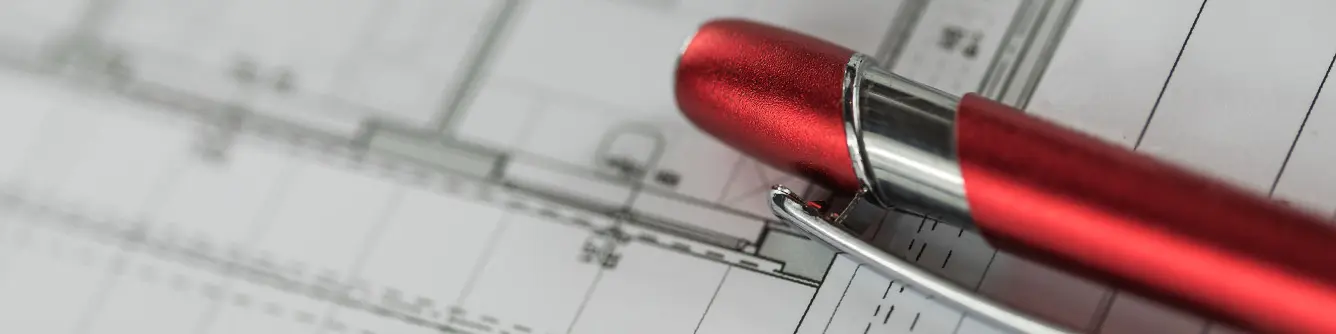 Red PREFA ballpoint pen on a plan
