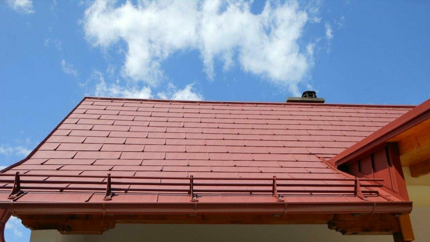 Detail of a roof surface with the PREFA FX.12 roof panel in oxide red with a snow load calculating system.