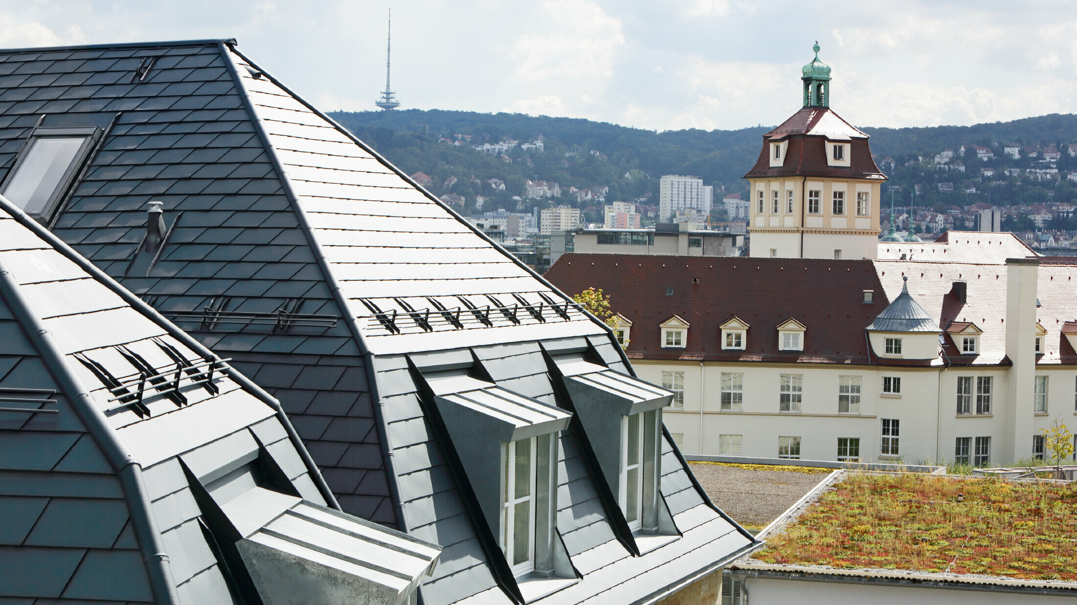 Old town house in Stuttgart with pitched roof and many dormer windows, roofed with PREFA aluminium shingle in P.10 anthracite