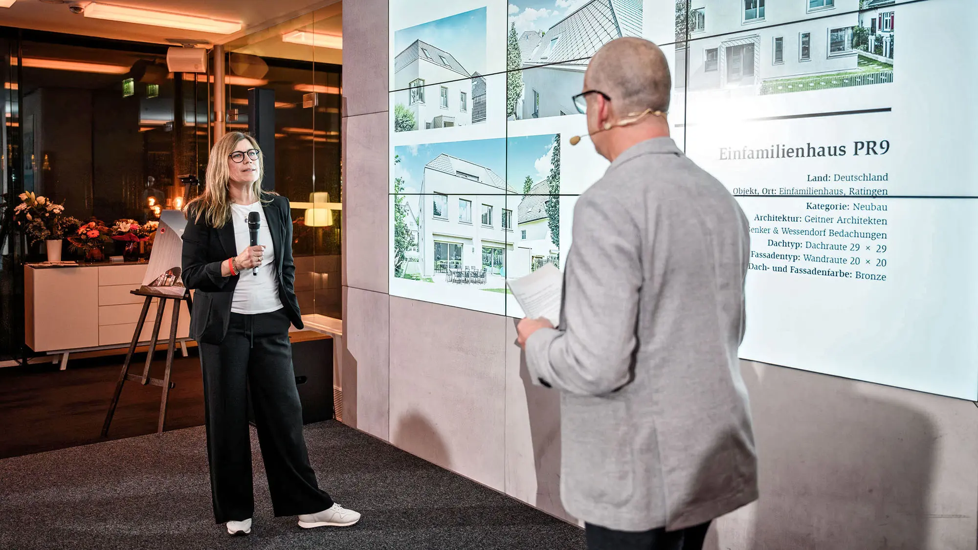 Architect Leona Geitner from the German office Geitner Architekten and International Marketing Manager Jürgen Jungmair talking in front of the presentation surface.