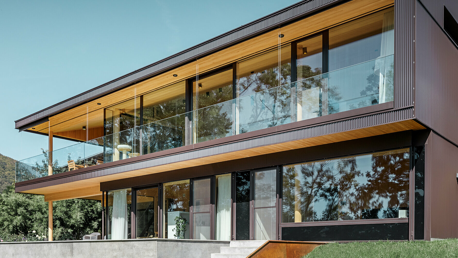 New detached house with large glass surfaces and brown aluminium façade