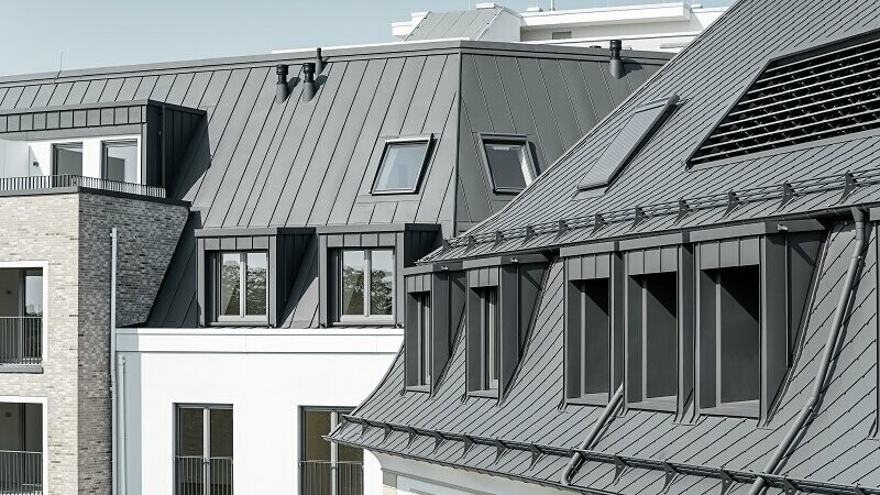View of the roofs of the "Marie" project. Rhomboid roof tiles 29x 29 and Prefalz in dark grey werde used to emphasise the high quality.