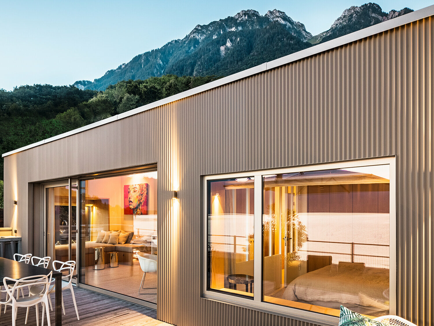 View of the terrace and part of the building interior in the evening.