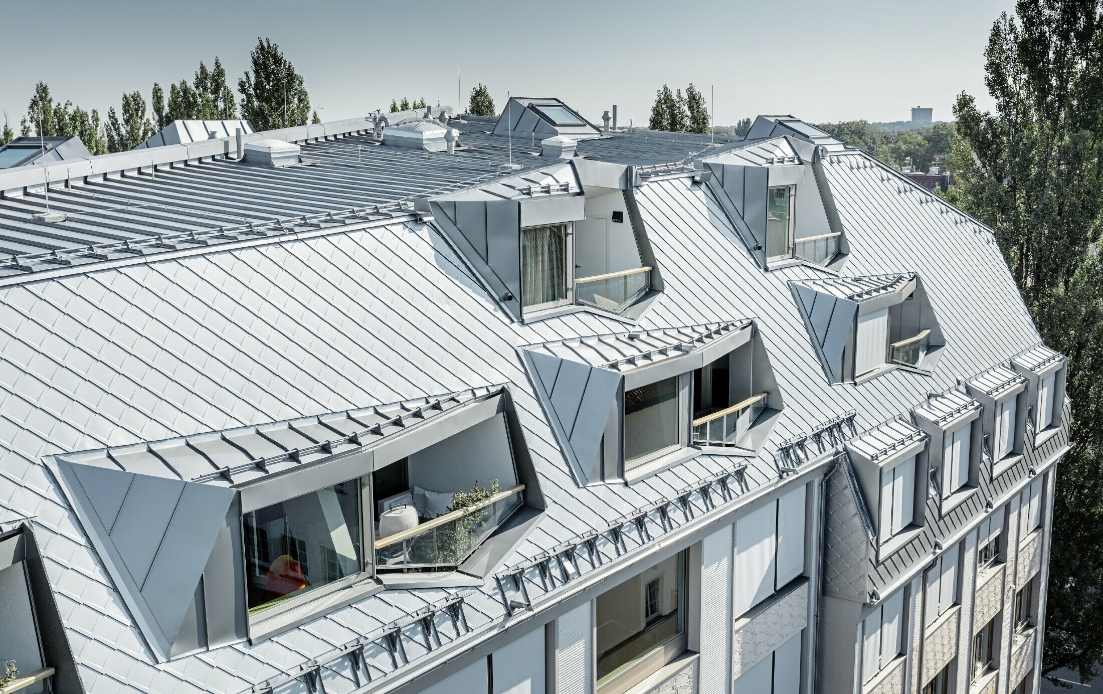 Renovated mansard apartments with large, open galleries in a residential and commercial building in Leopoldstraße/corner of Hohenzollernstraße in Munich (Germany), with a roof covering made of PREFA rhomboid roof tiles