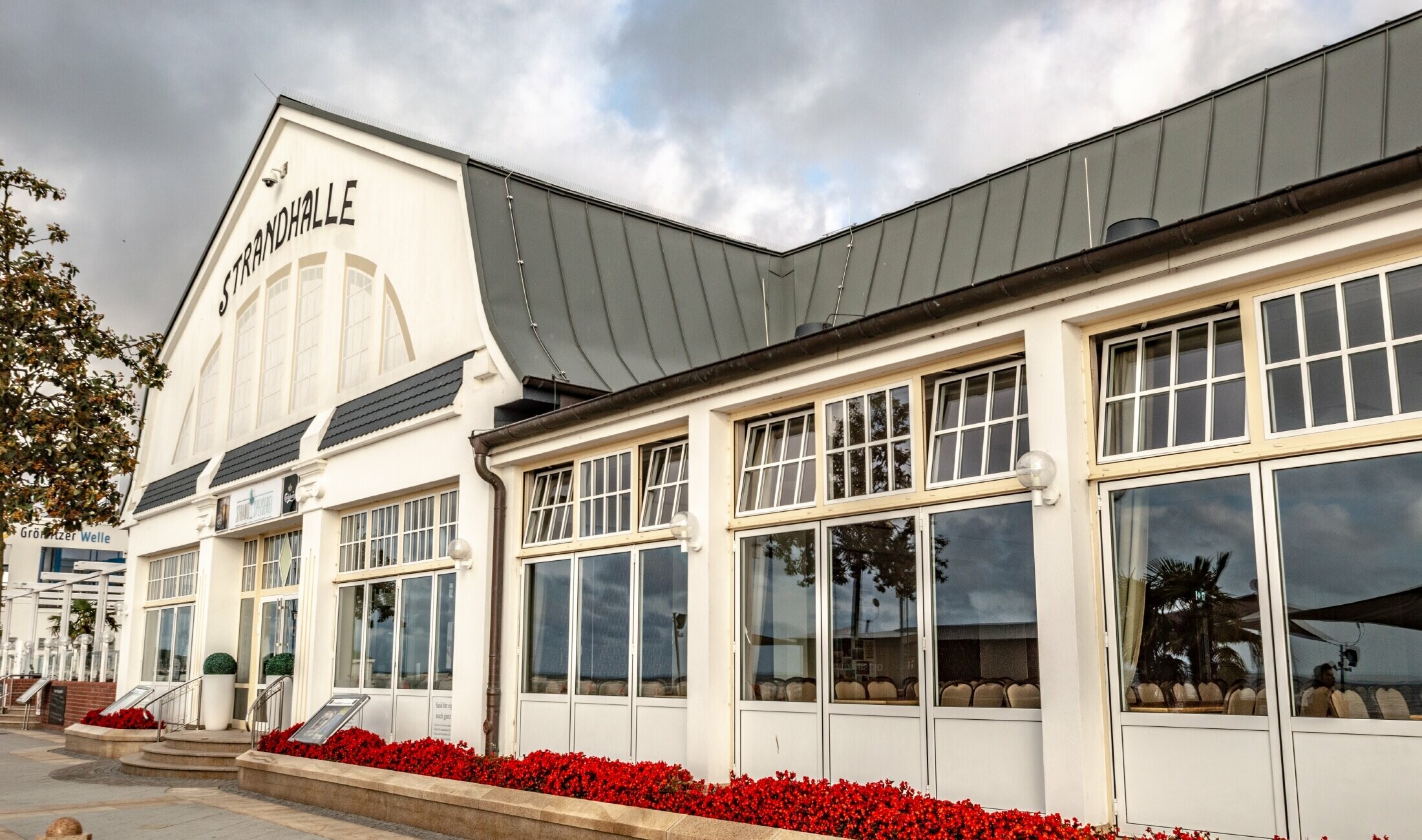 Beach hall in Grömitz with the PREFA standing seam roof in light grey and large windows facing the beach.