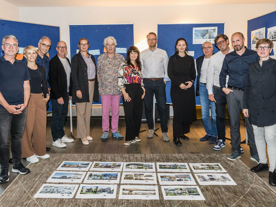 Group photo of the PREFARENZEN 2026 jury after the successful selection process in a winegrower's residence in Seewinkel, Burgenland: The interdisciplinary group of experts consisting of Dirk Lorenz (Leinert Lorenz Architekten), Veronika Roll (Marketing, PREFA Austria), Wolfgang Croce (Croce & Wir, Graz), Jürgen Jungmair (Head of International Marketing, PREFA), Judit Nemere (Managing Director, PREFA Hungary), Matthias Finkentey (Moderator), Bettina Almeida (Communications Management, PREFA), Christian Wirth (Regional Manager East, PREFA Austria), Selina Wach (Head of Discourse, Architektur Aktuell), Thomas Schlett (B3 Architekten), Sven Disser (Head of Development, Bauwerk), Falk Leinert (Leinert Lorenz Architekten) and Juliane Croce (Croce & Wir, Graz) stands in front of the final architectural projects selected for the PREFARENZEN architecture book and the 2026 calendar. The projects reflect diversity, sustainability and innovative use of PREFA materials.
