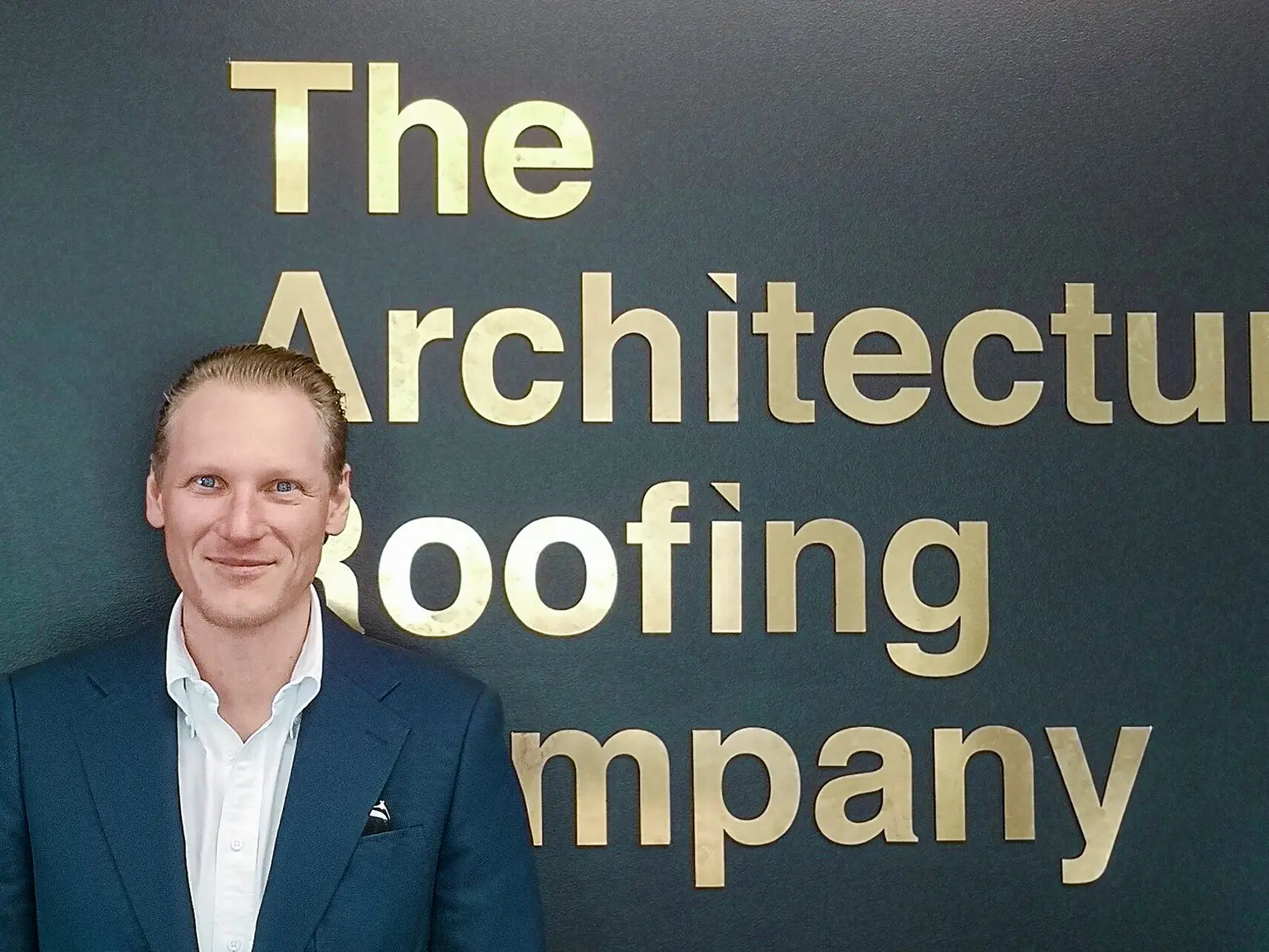 Portrait of the installer Johan Vogl, the office name "The Architectural Roofing Company" in the background.