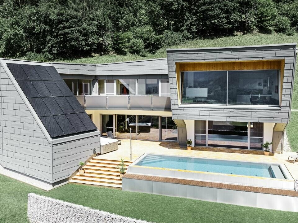 Extravagant detached house with pool and photovoltaic system, covered with PREFA FX.12 roof and façade panels.