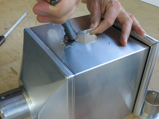 Step 3 for creating an emergency overflow in a PREFA leader head — Cut out a hole around the marking.