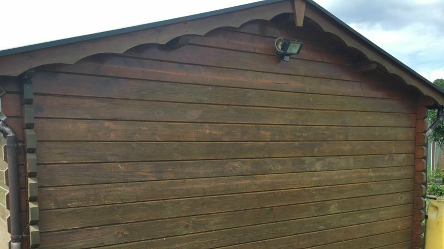 Summer house before renovation with weathered wood; it is now clad with wood-effect PREFA sidings