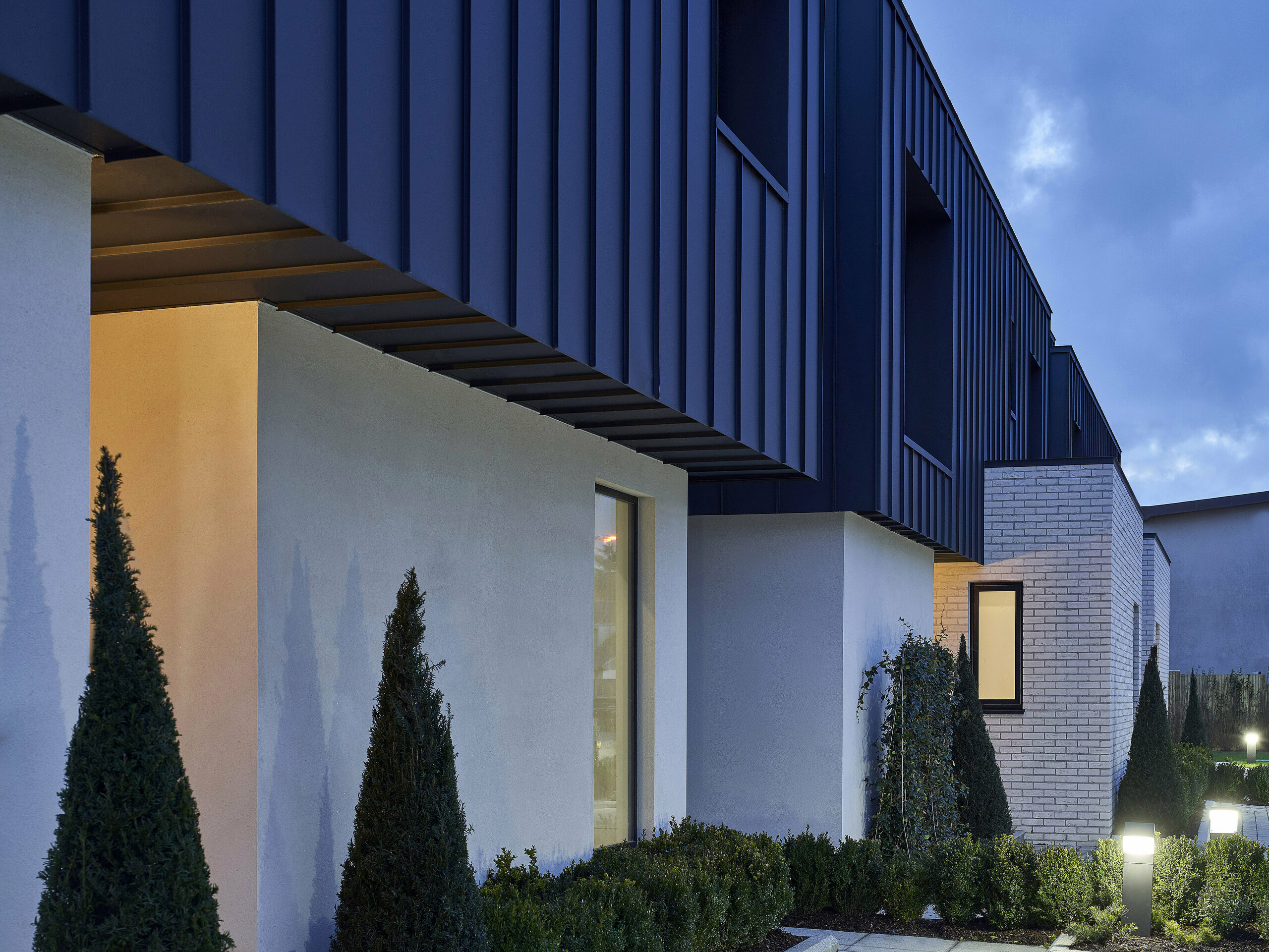 Detail picture of the residential houses with PREFALZ in the colour P.10 anthracite in the evening.