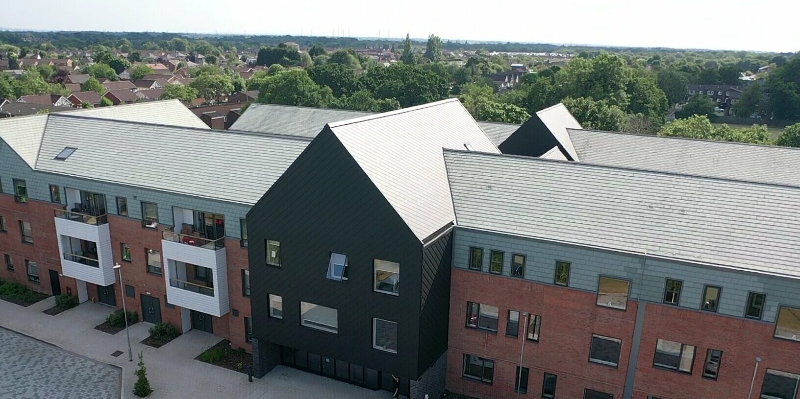 Bird's eye view of the entrance to the care facility in Preston clad with PREFA rhomboid roof and facade tile 29 × 29 in P.10 Black