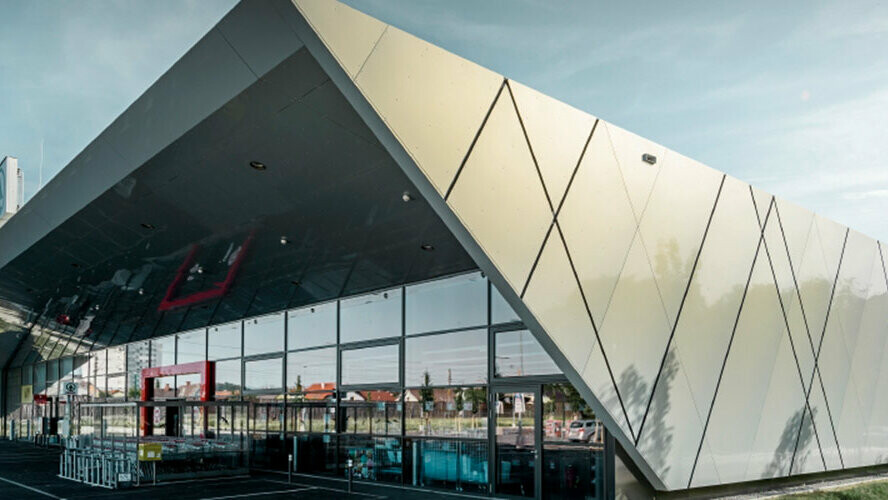 Spar branch in Wels with a modern aluminium façade clad with PREFA composite panels in silver gold.