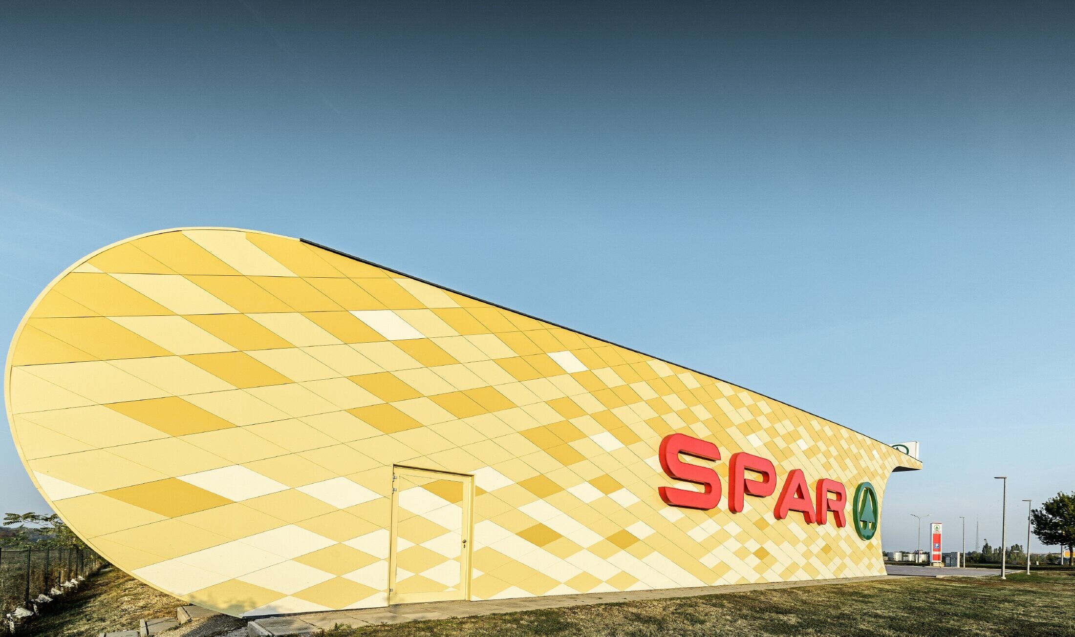 Spar branch with an aluminium façade in yellow and orange checks and the Spar logo