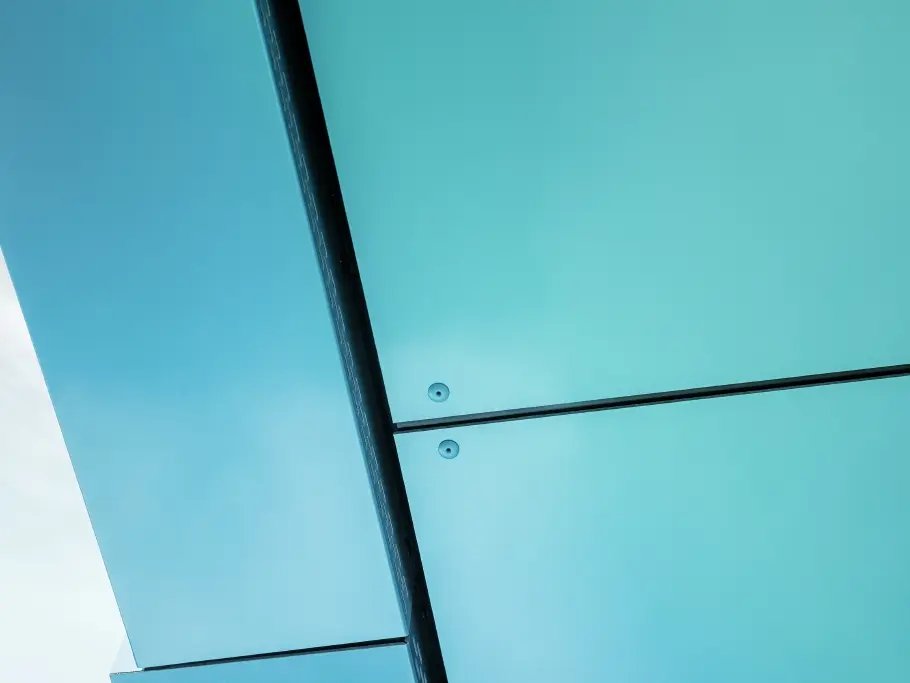 Detail view of the façade covered in PREFABOND composite panels in green-blue.