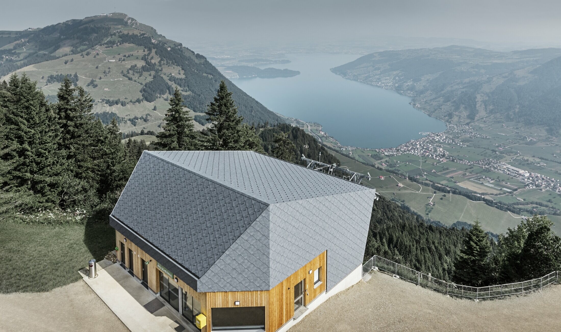 Aerial view of the Rigi Scheidegg cable car mountain station clad in the PREFA 44 x 44 rhomboid façade tile in P.10 stone grey and wood.
