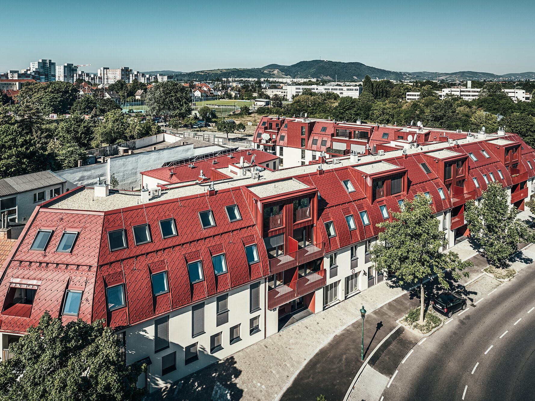 Bird's eye view of the elongated roofscape made of numerous small rhomboid tiles.