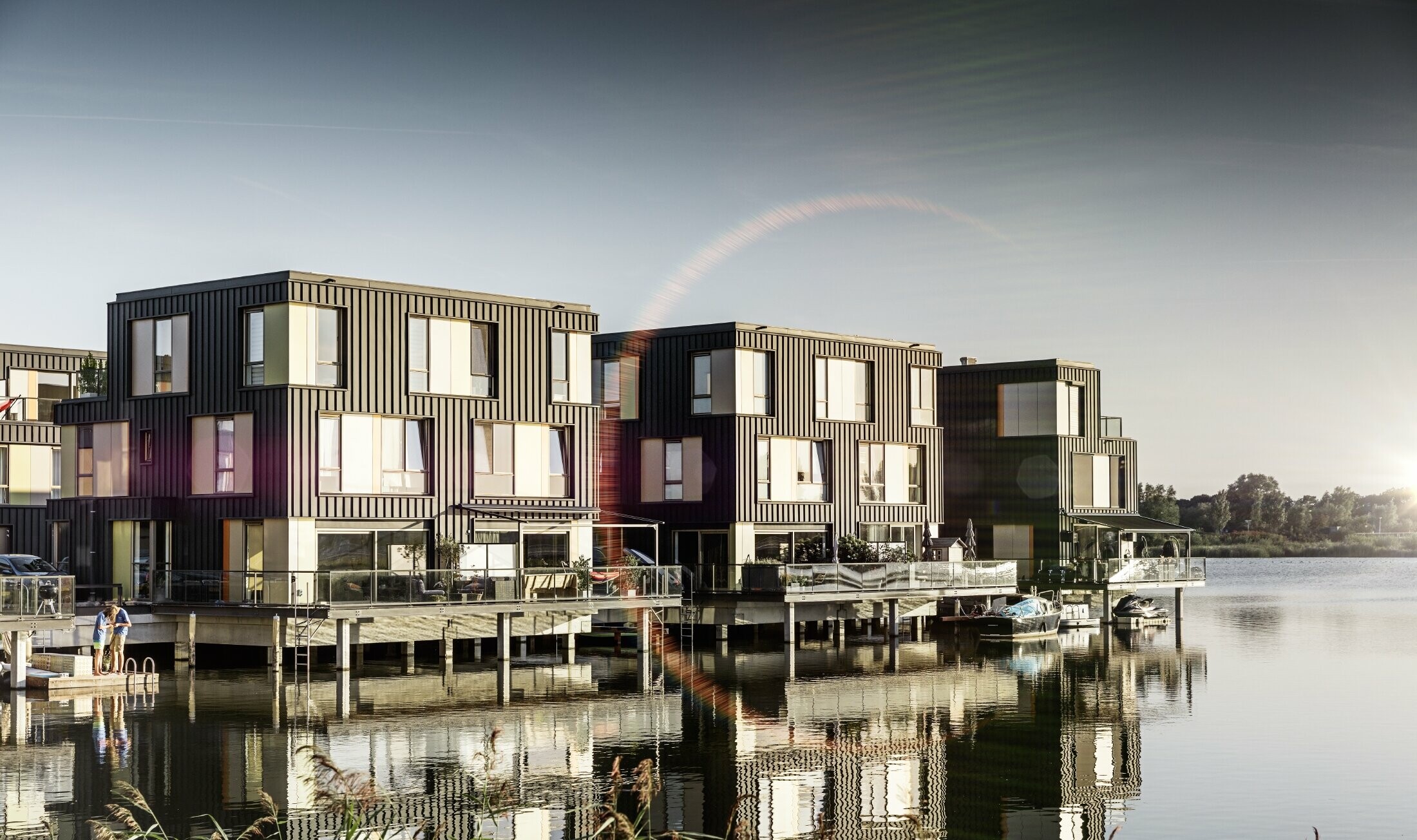 Settlement with semi-detached houses on a lake clad in PREFA Prefalz in P.10 anthracite.