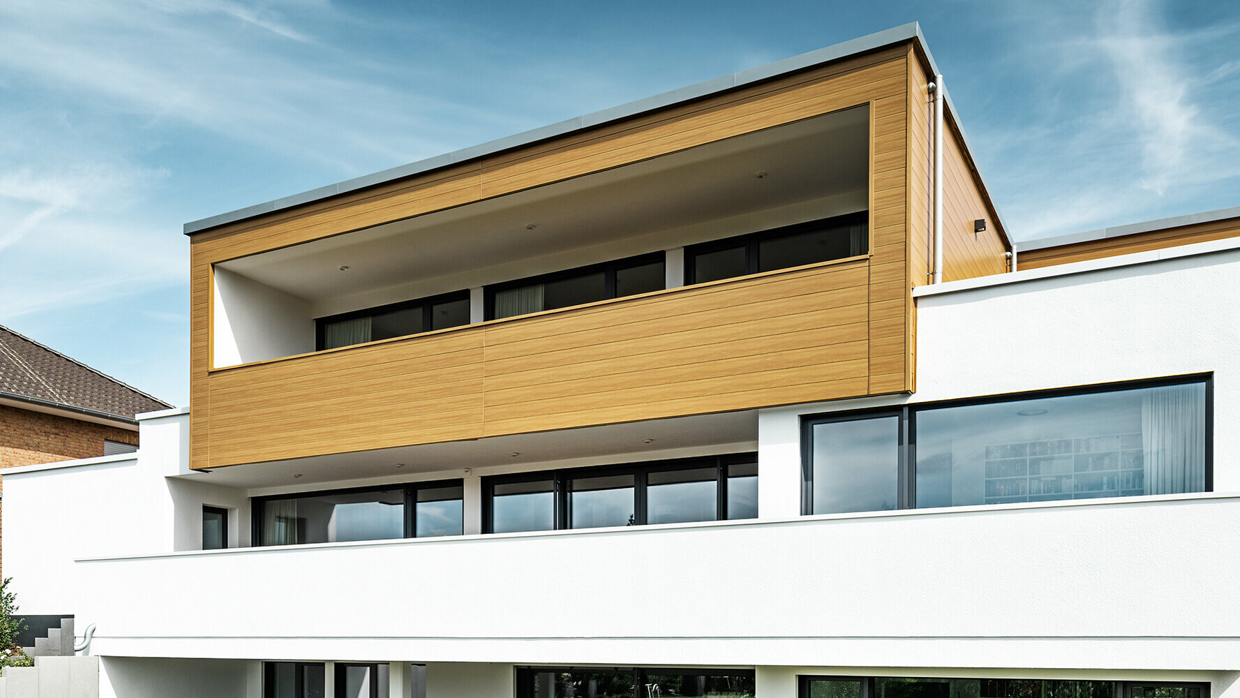 Modern residential building with bay window, which is clad with natural oak PREFA sidings.