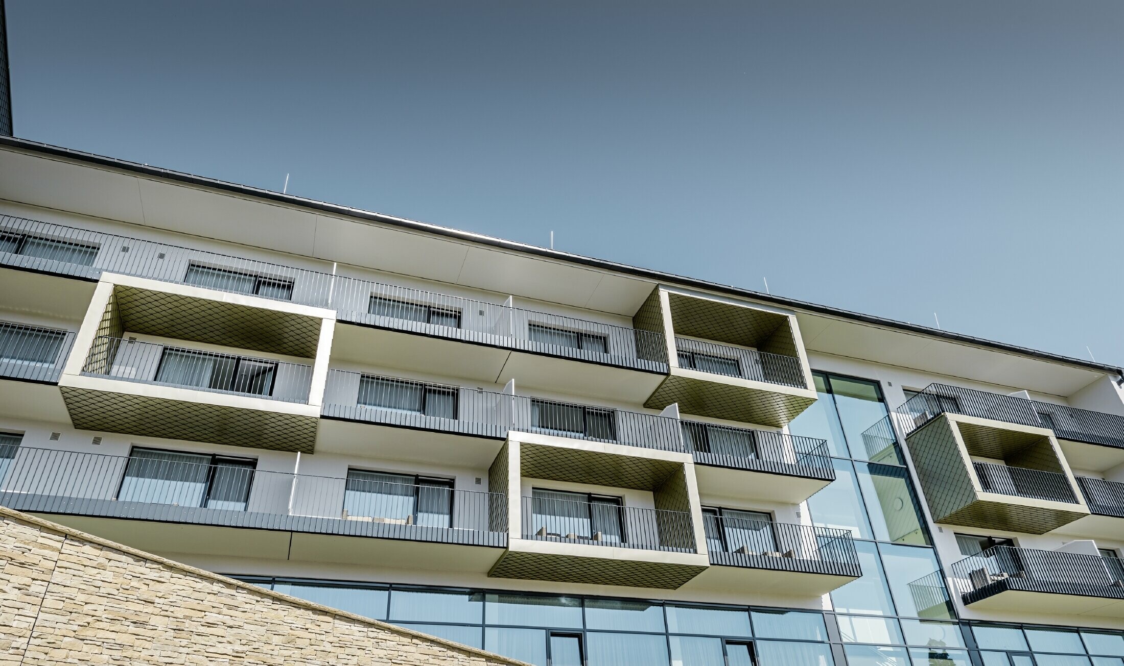 Balcony cladding at Hotel Edita in Scheidegg with the PREFA rhomboid façade tile in light bronze