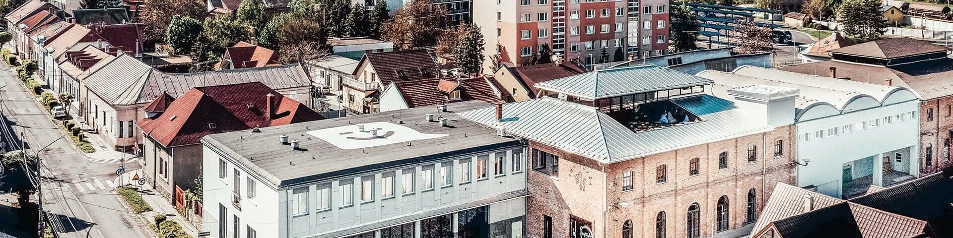 Bird´s view of the Smaltovna building. The roof is clad with Prefalz in plain aluminium. In the background several buildings of the city can be seen.