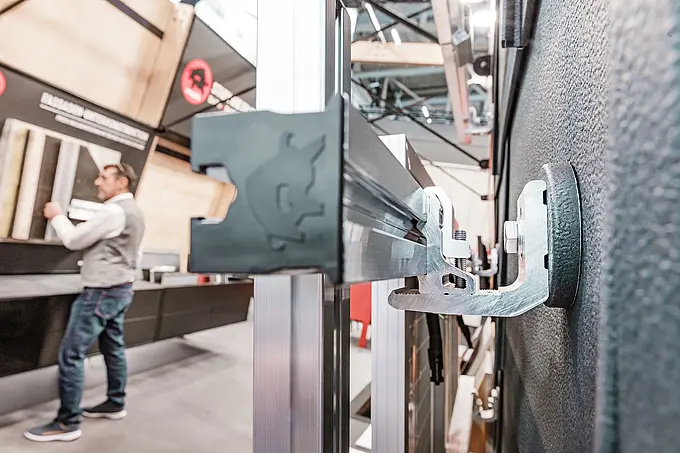 Das Solarmodul-Montagesystem PREVARIO von PREFA im Detail: Die robusten Aluminiumträger ermöglichen eine stabile Montage auf verschiedenen Dachkonstruktionen. Langlebig, korrosionsbeständig und ideal für die effiziente und zeitsparende Installation von Photovoltaikanlagen. Die Seitenansicht bietet einen interessanten Einblick in das stabile PV-Montagesystem. Im Hintergrund ist ein PREFA-Mitarbeiter zu sehen. Das Bild entstand im Rahmen der BAU München 2025, wo das innovative Produkt erstmals präsentiert wurde.