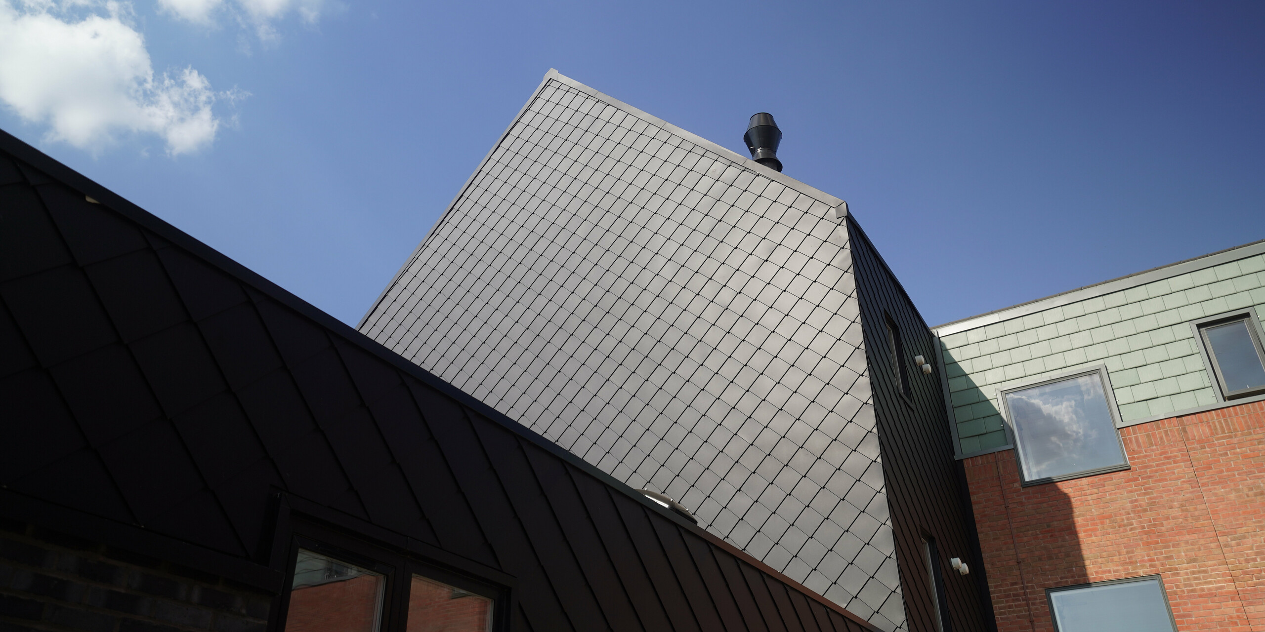 PREFA rhomboid tile 29 × 29 in P.10 Black on the façade of a care facility in Preston