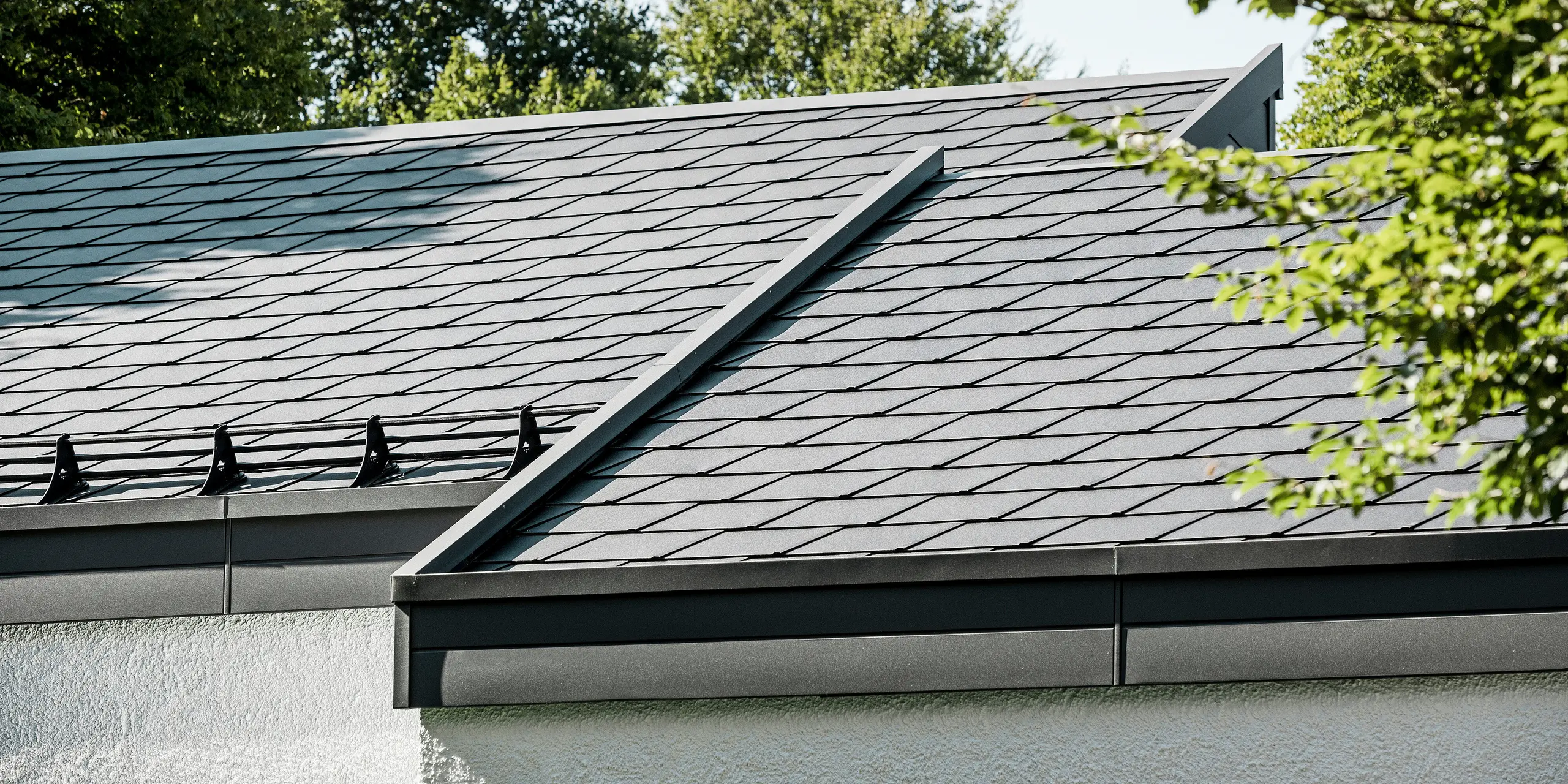 Ein Einfamilienhaus, das mit PREFA Dachschindeln DS.19 in schwarz eingedeckt wurde. Für Teile der Fassade wurden PREFA Sidings in P.10 dunkelgrau verwendet. 
