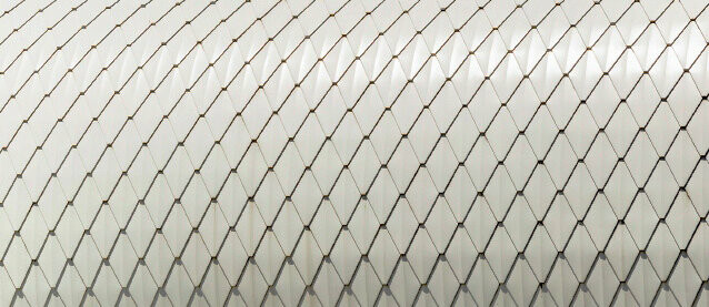 Detailed view of PREFA’s small rhomboid tile in pure white on rounded façade
