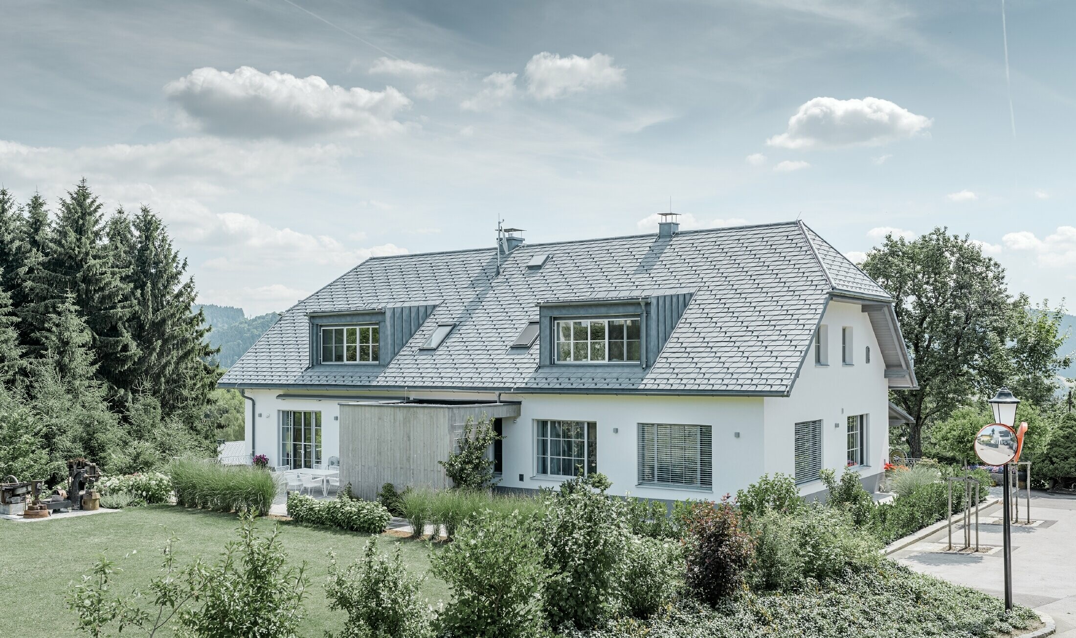 Refurbishment of a half hipped roof with the light PREFA roof shingles in stone grey with two dormers.