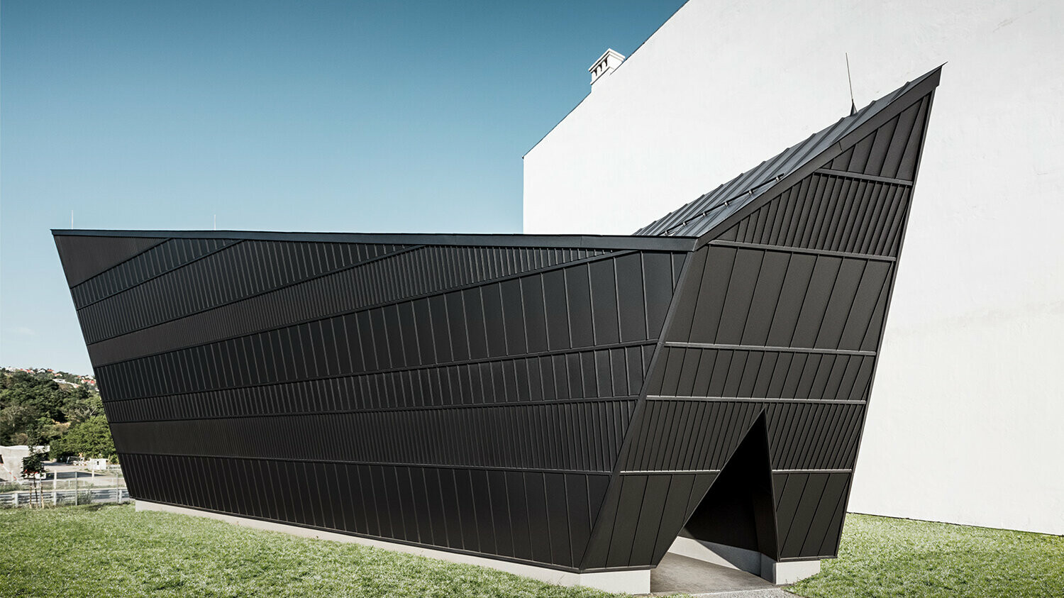 The new cinema pavilion, clad with black aluminium, of the museum in Skanzen from a lateral perspective, designed by the architect István Bársony.