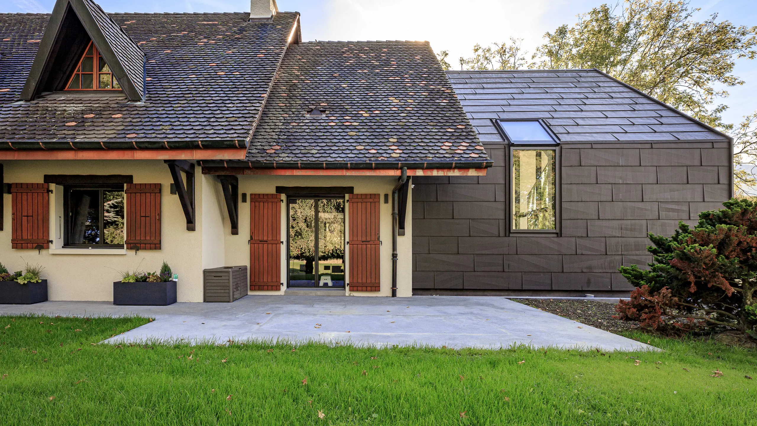 PREFA FX.12 roof and façade panels in P.10 brown, used as a striking design feature on the extension of a detached house in Lully