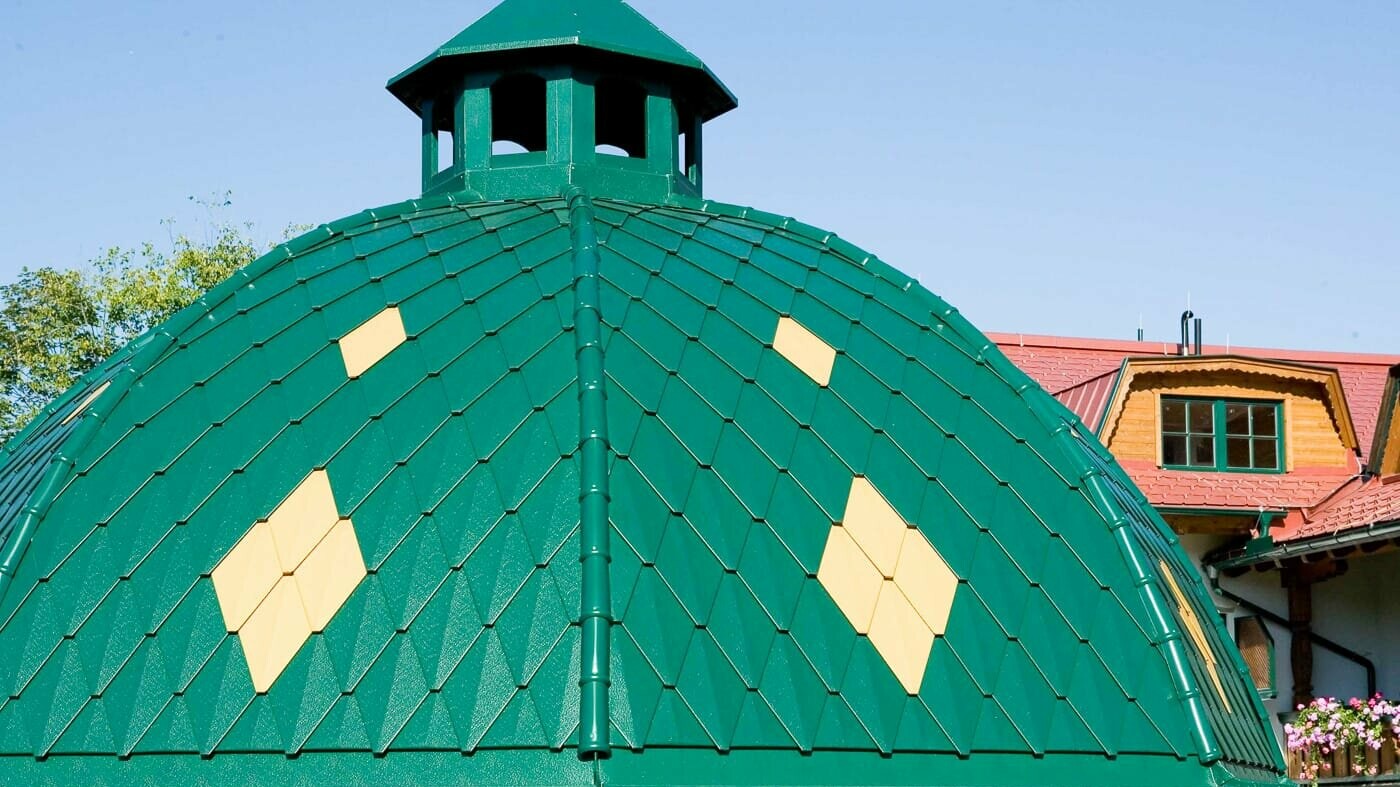 Round dome covered with PREFA’s small rhomboid tile in moss green