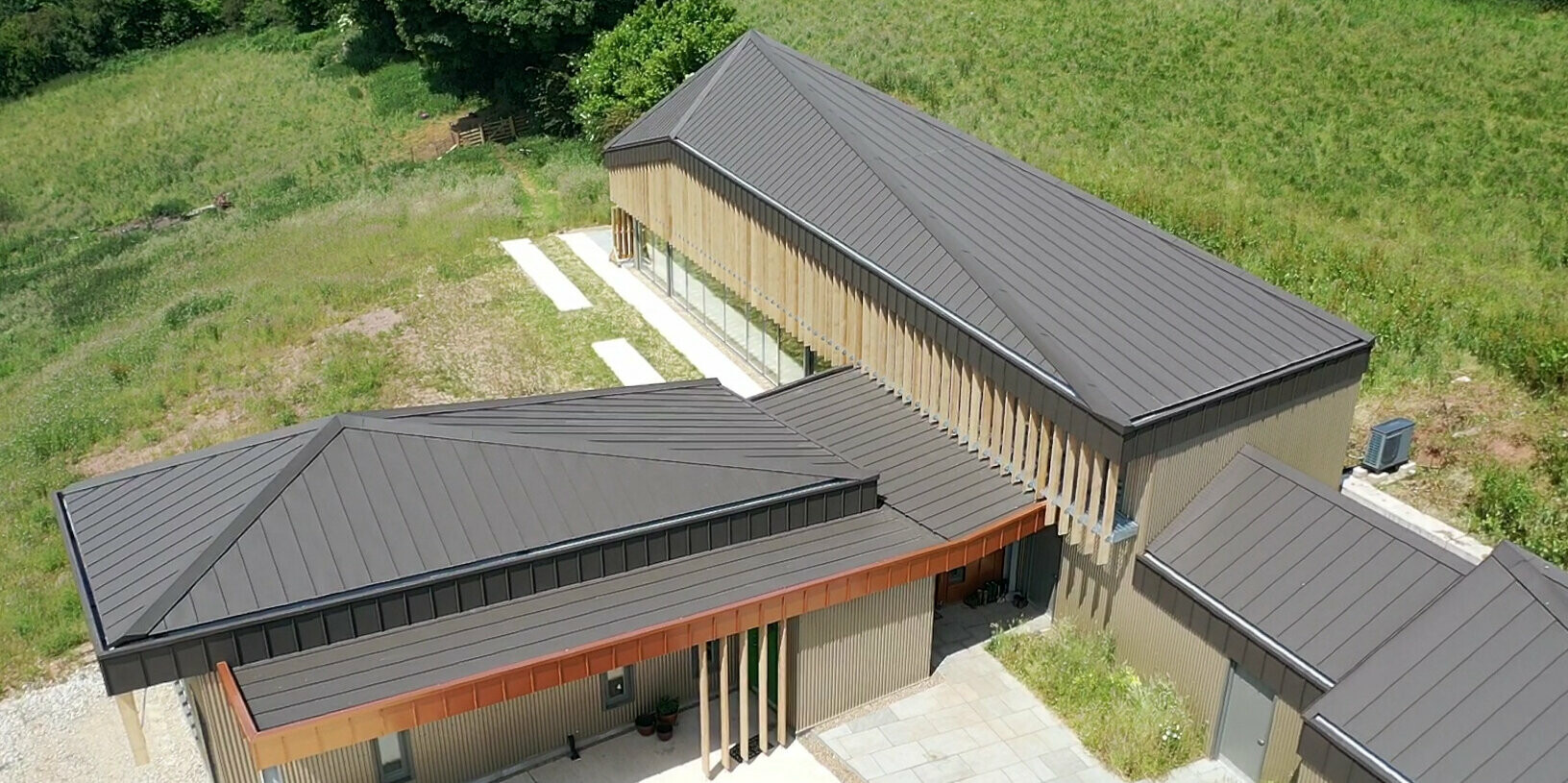 Bird's eye view of the entrance to a longhouse in Derbyshire with a PREFA Aluminium Roof in Brown
