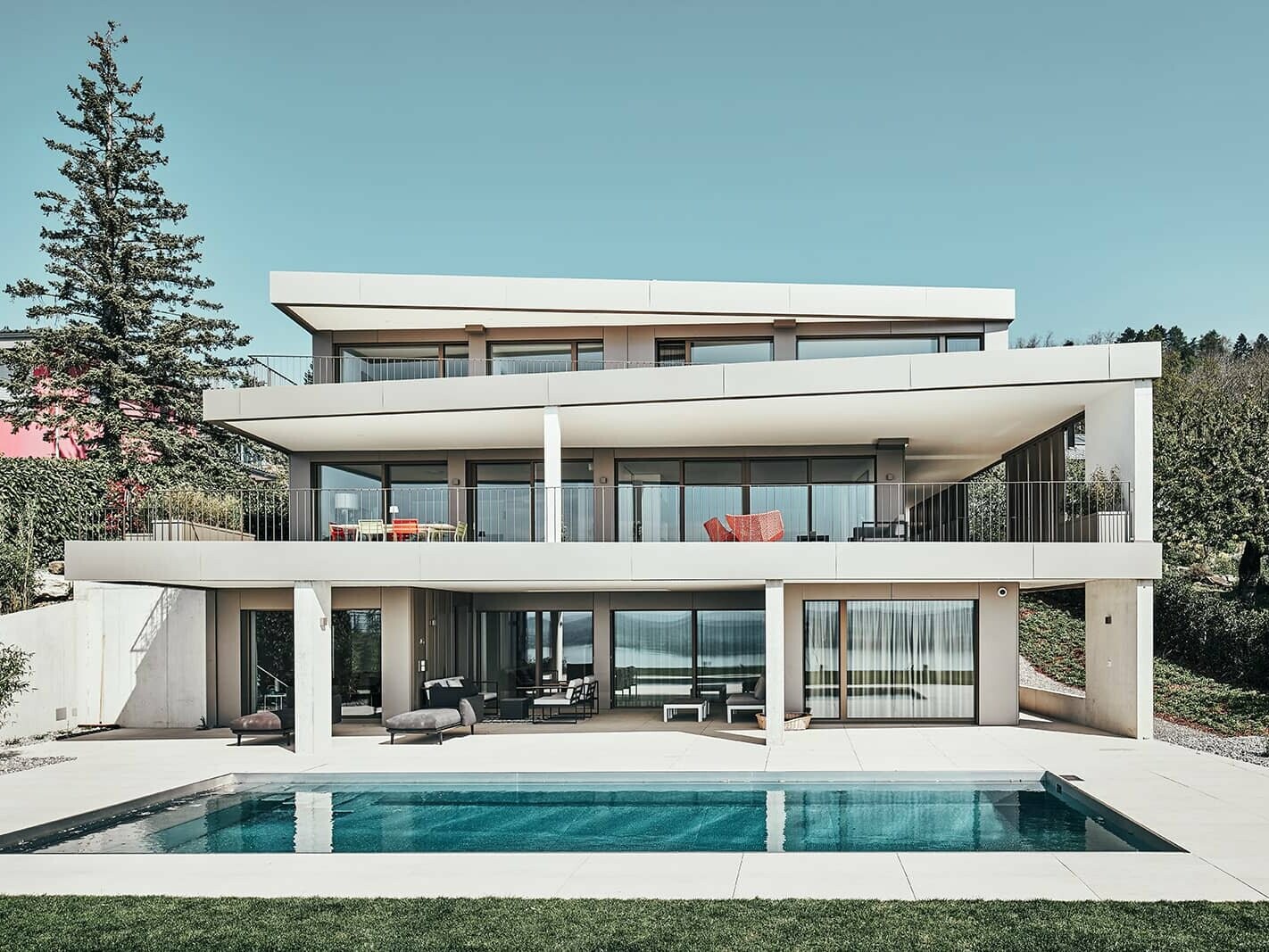 Front view of the detached house in Switzerland. You can see the pool in front of the house.