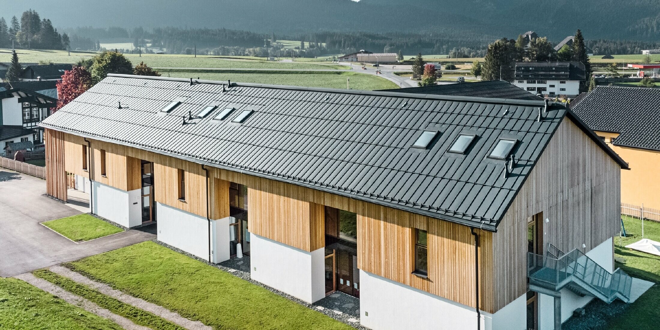 Herb kindergarten in Bad Mitterndorf with large PREFALZ roof in P.10 anthracite and wooden façade