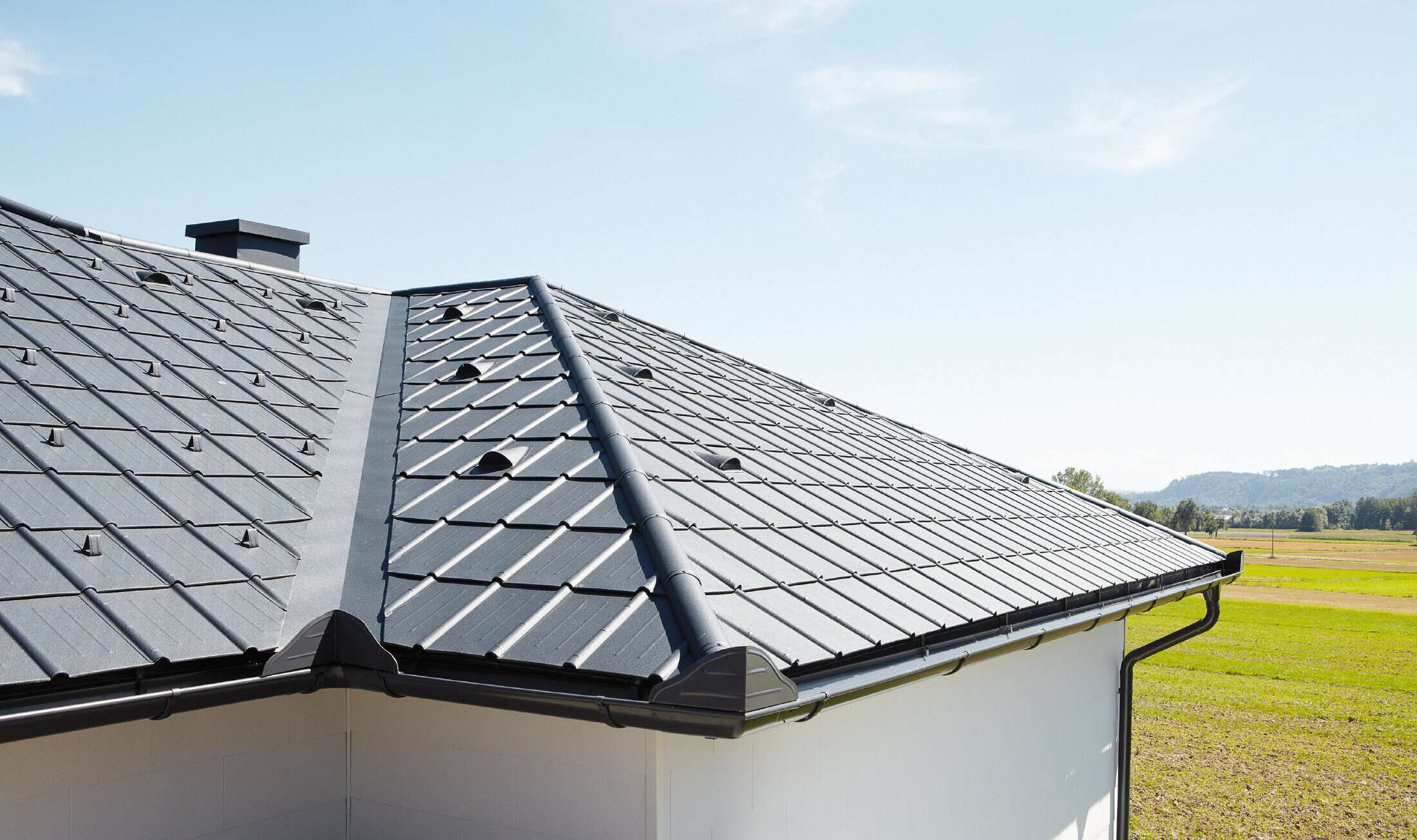 Detached bungalow, the roof is covered with PREFA roof tiles and the gutter in anthracite, you can also see a valley