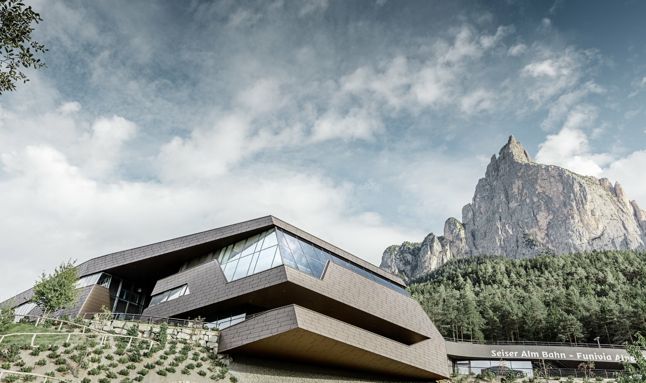 Redesigned valley station for the Seiser Al shuttle service in Italy, resembling the Dolomites in the background with irregular edges and surfaces, and an aluminium façade in brown by PREFA