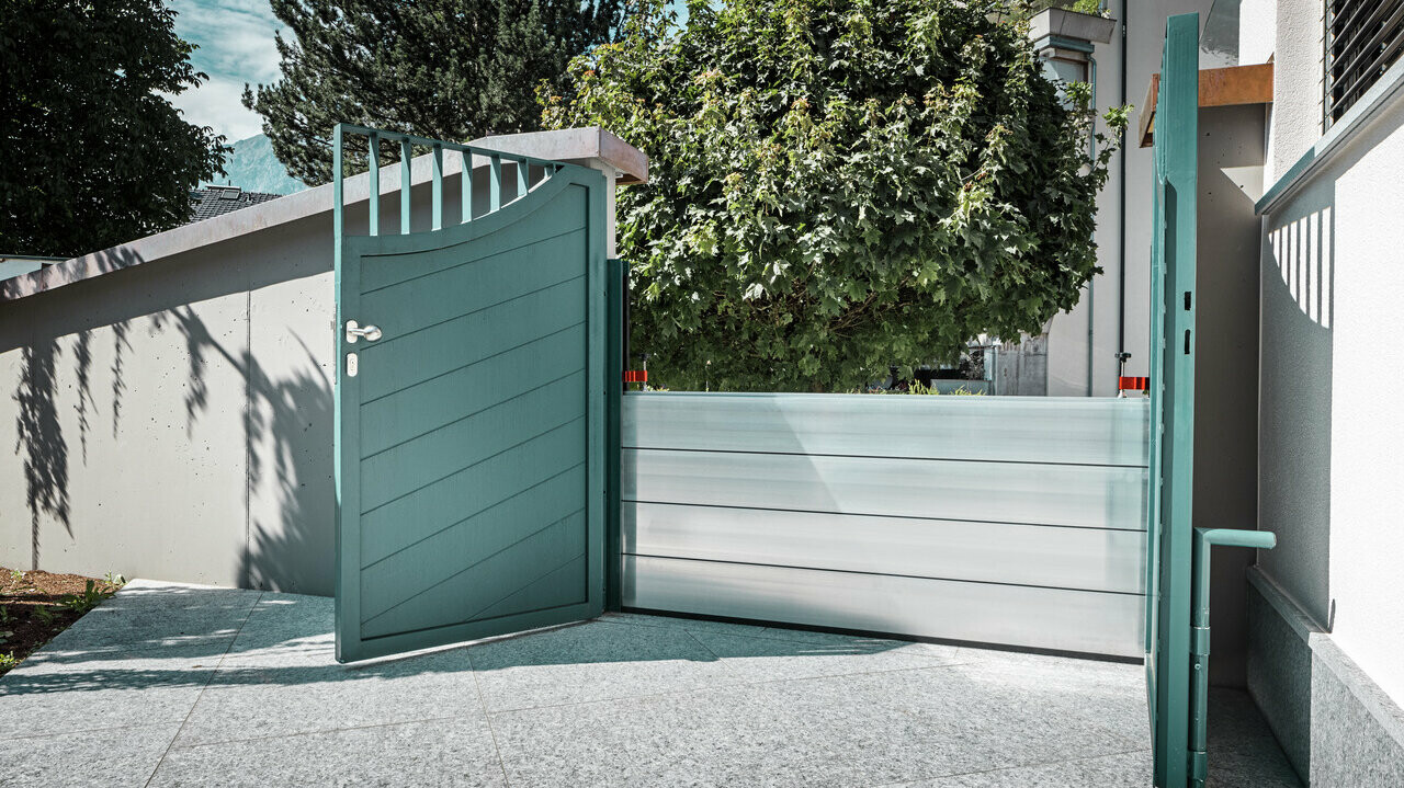 Here you can see the PREFA flood protection already installed in front of a large green gate, which will protect the detached house behind it from flooding.