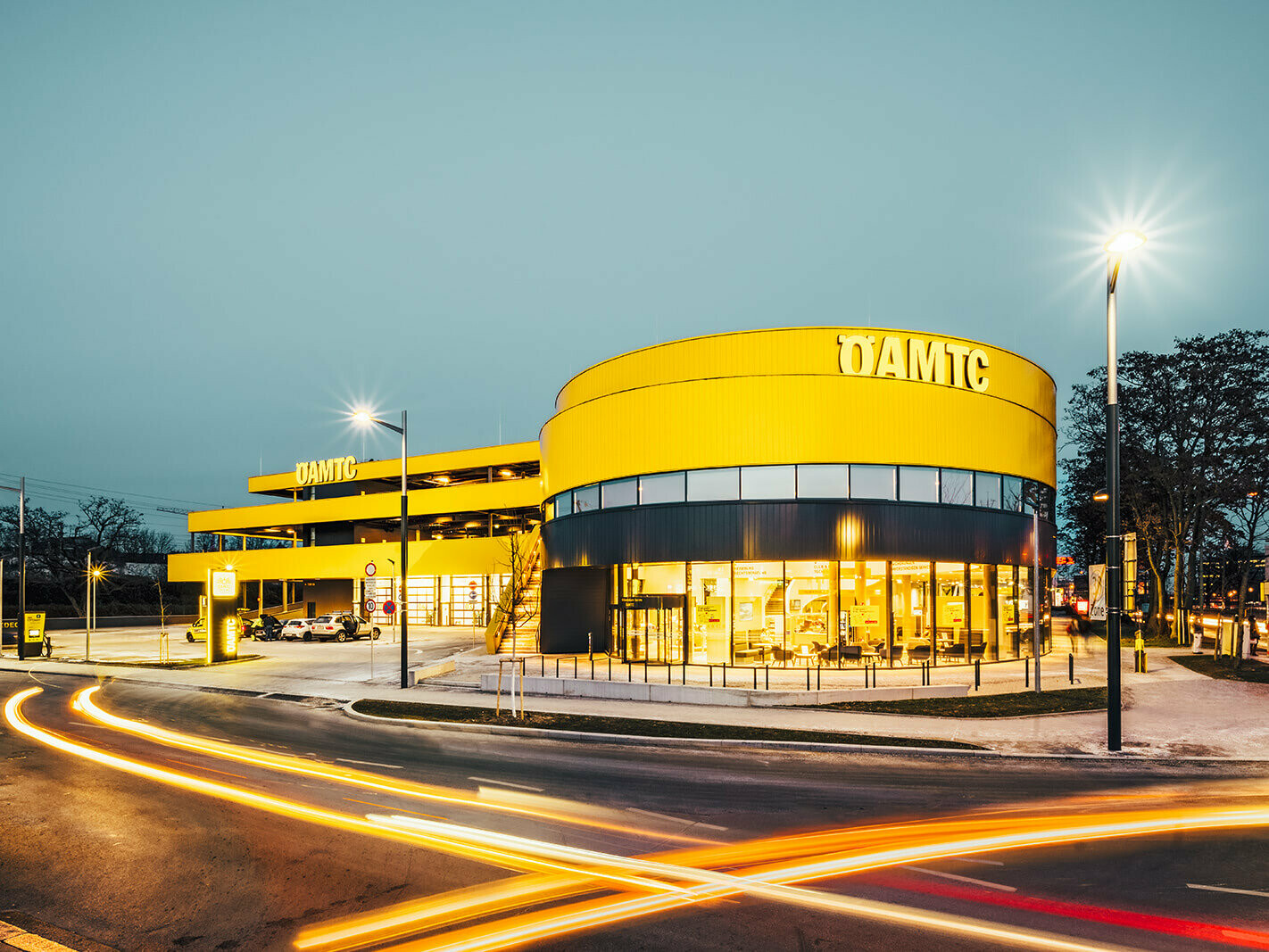The ÖAMTC Center in Vienna by night. The building is covered in PREFA Sidings in the colour rapeseed yellow.