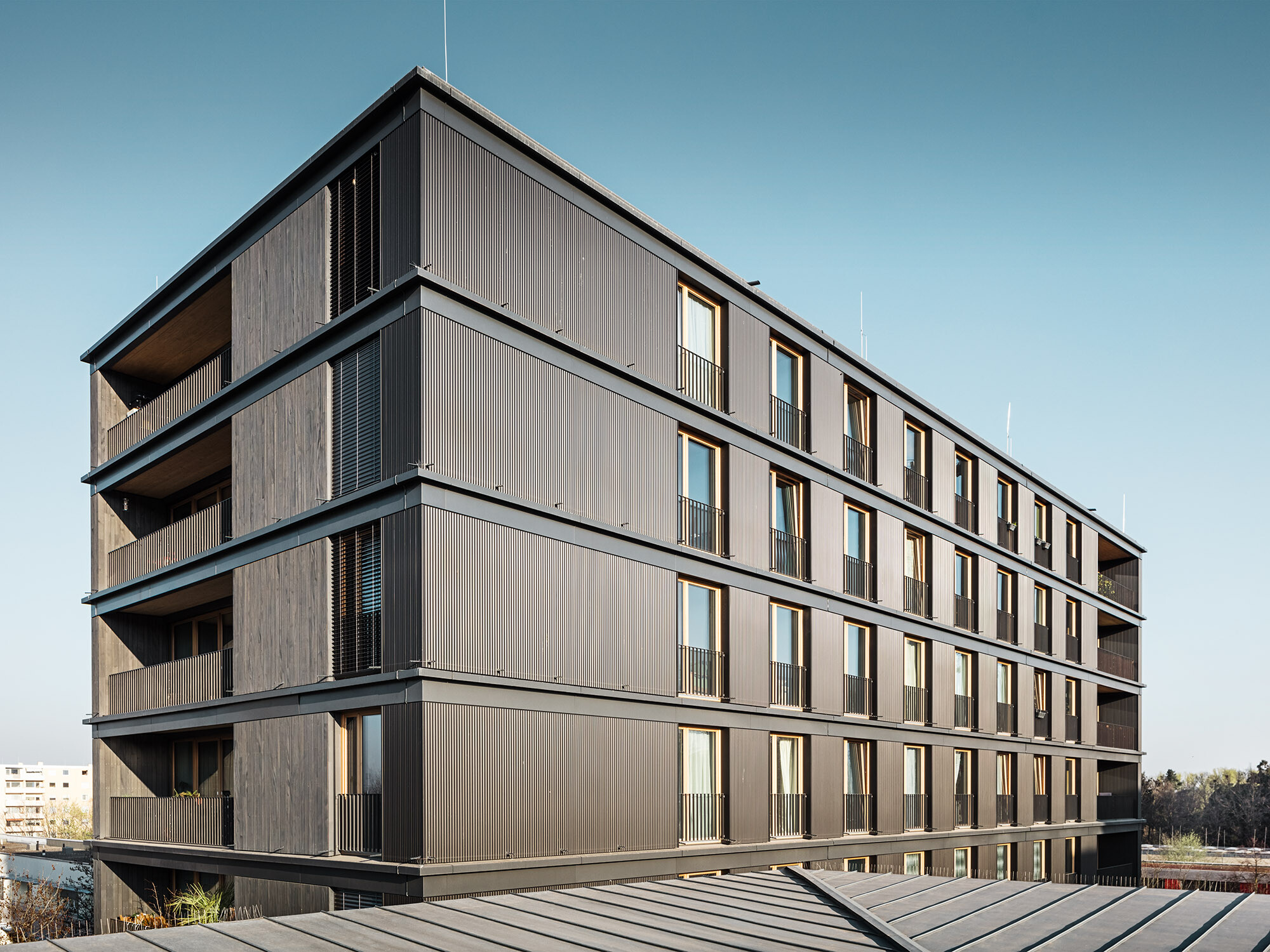 The residential and commercial building from the side: it is difficult to tell the difference between the PREFA ripple profile and the timber façade.