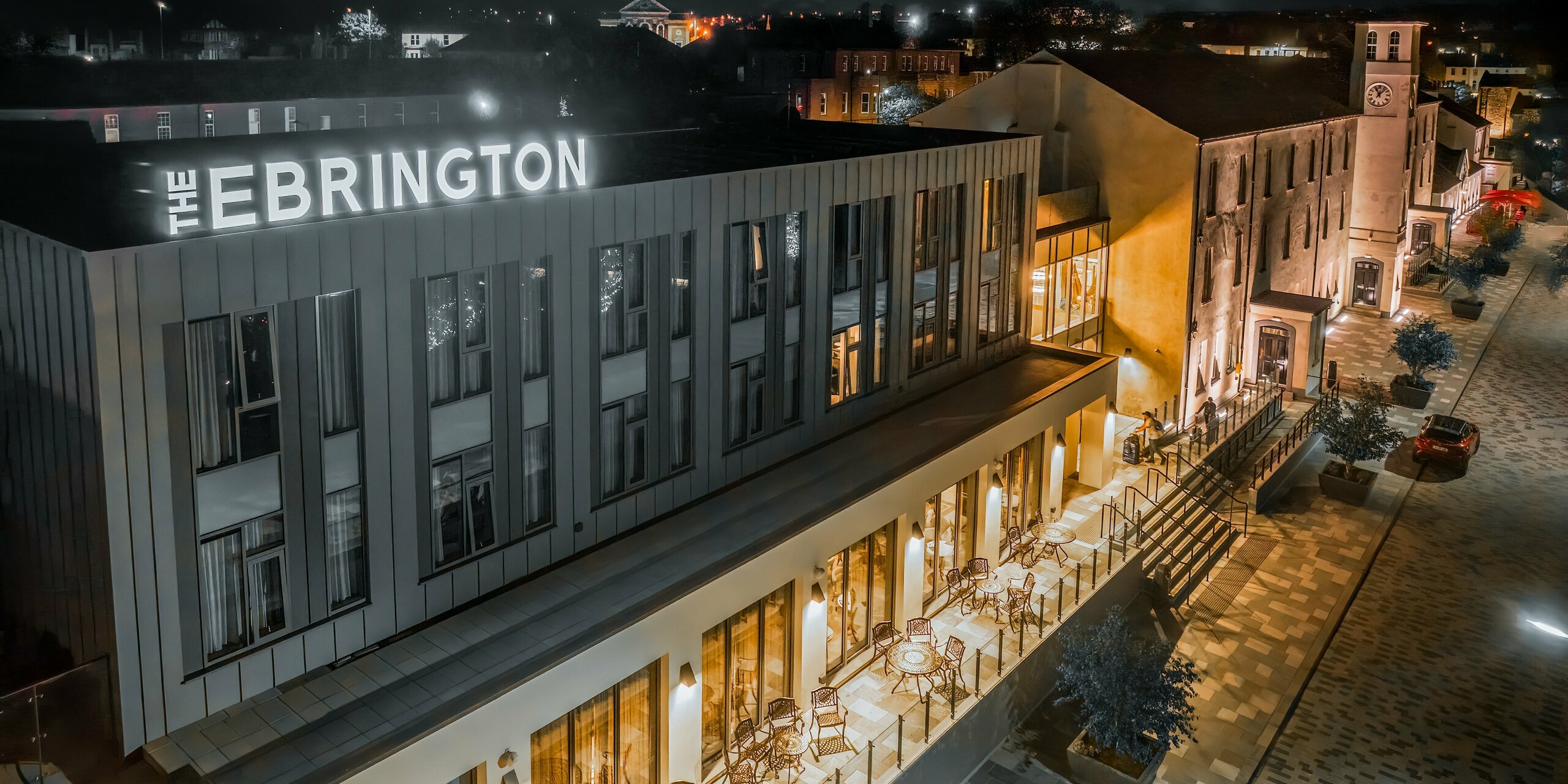 The Ebrington Hotel at night stands out with its impressive lighting in a pedestrianised area in the centre of Londonderry, Northern Ireland. The modern guest house was clad with robust PREFALZ aluminium cladding in the colours P.10 light grey and P.10 zinc grey. This high-quality sheet metal façade protects the building from the elements. The standing seam cladding also acts as a highlight in the sleek architecture.