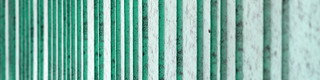 Detailed view of the patina green aluminium façade, rhythmized with differently wide trays. The colour creates a speckled appearance.