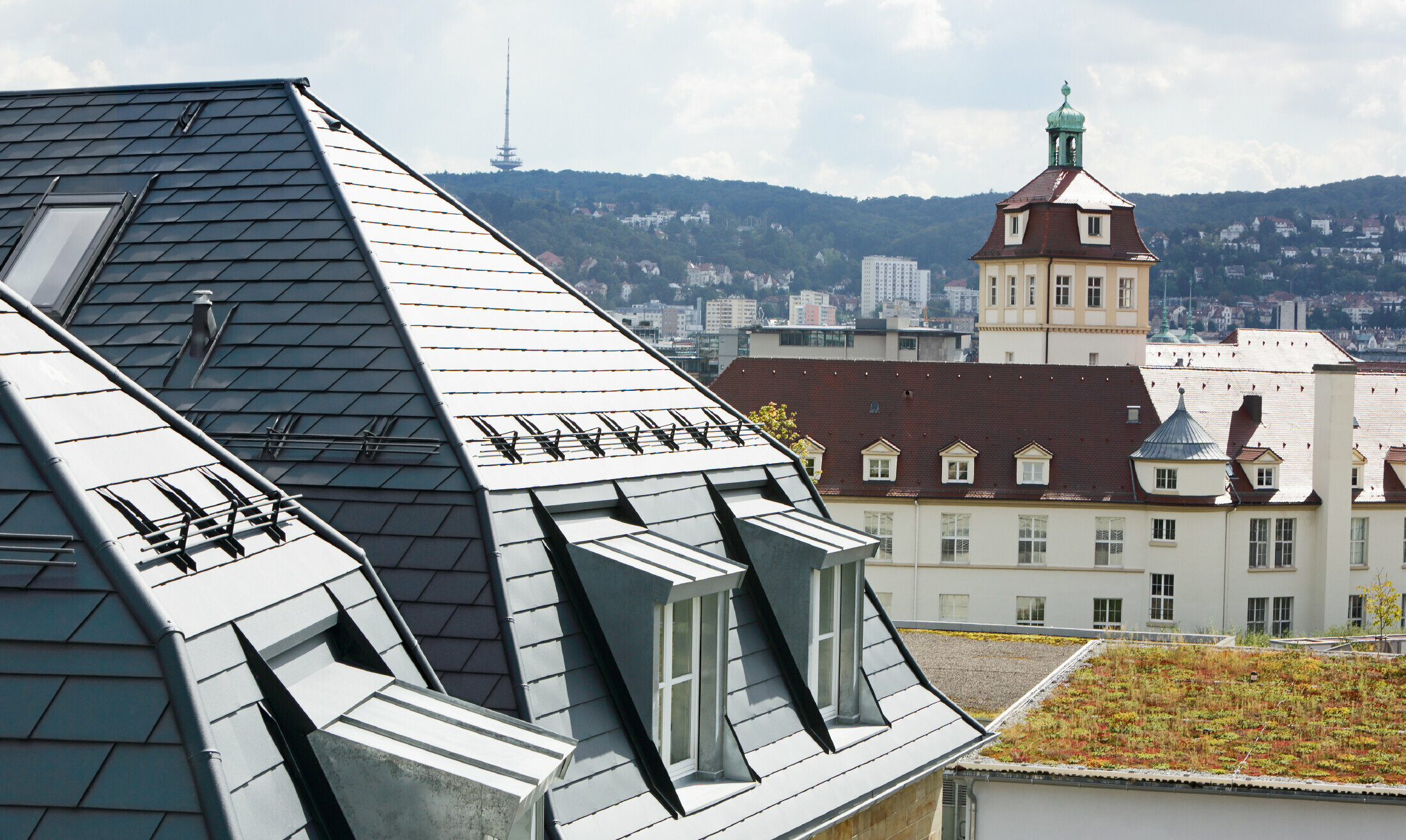 Old town house in Stuttgart with pitched roof and many dormer windows, roofed with PREFA aluminium shingle in P.10 anthracite