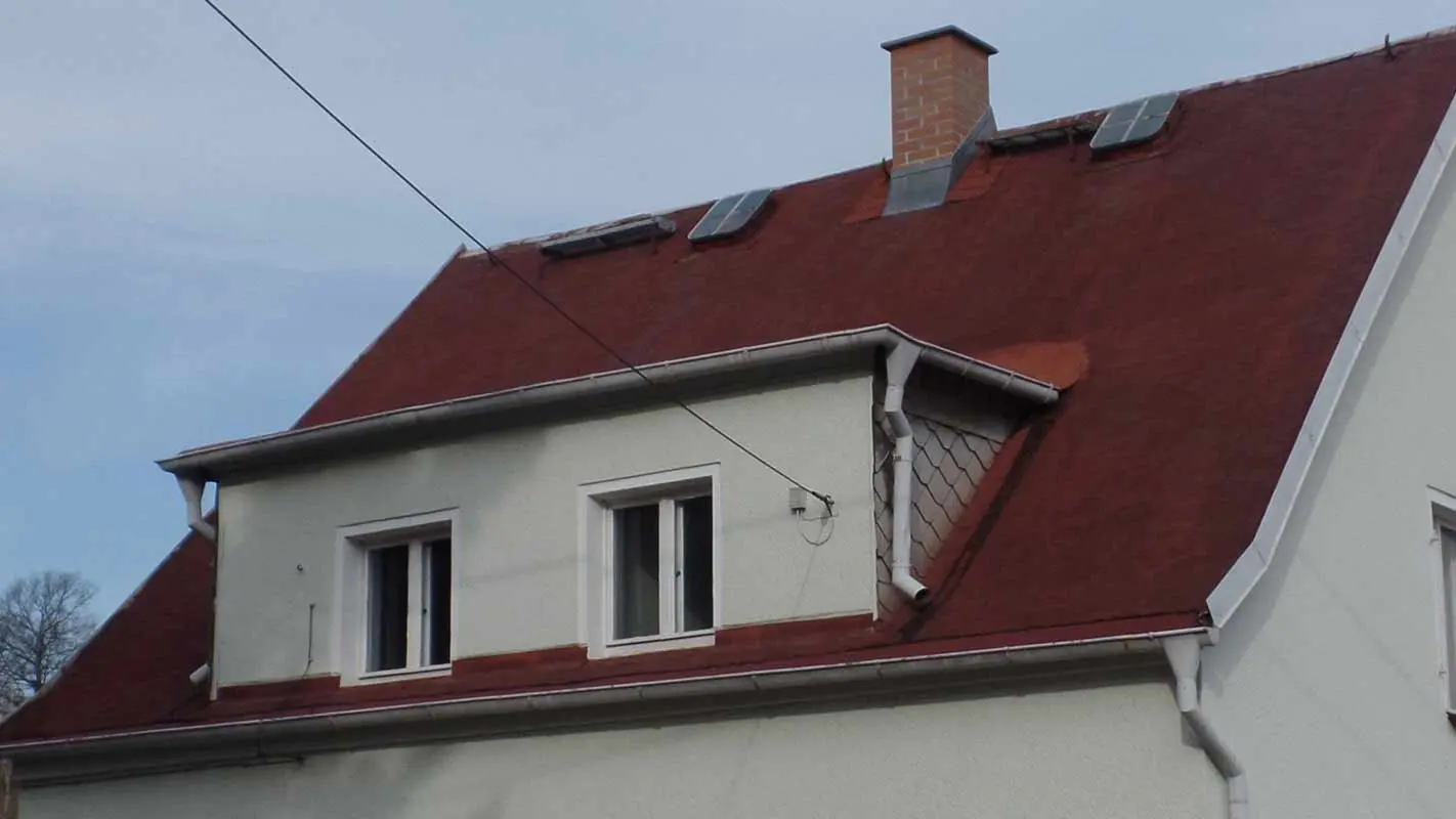 Property with eyebrow dormer renovated with PREFA shingles